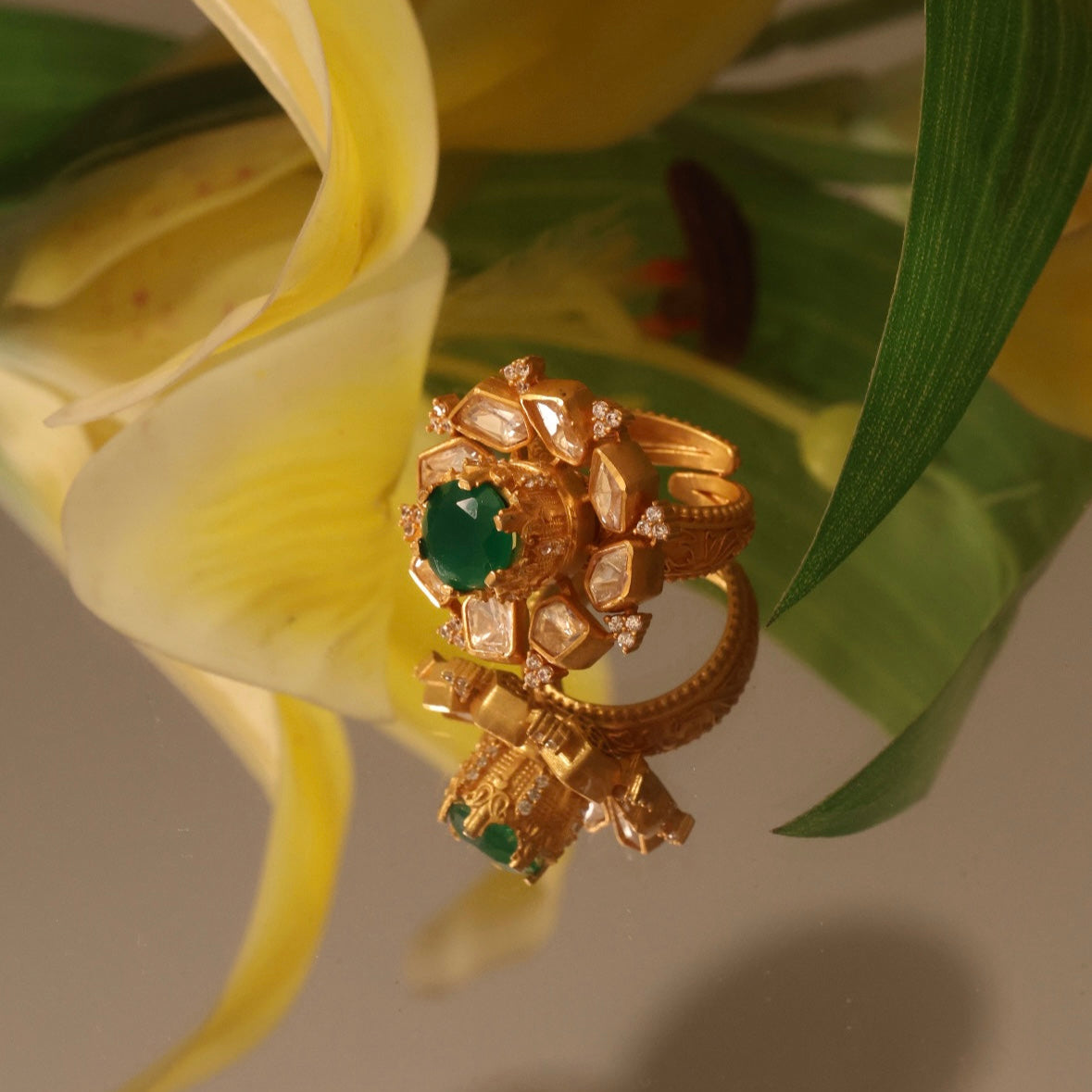 Gold-plated moissanite ring with emerald centerpiece and intricate floral design