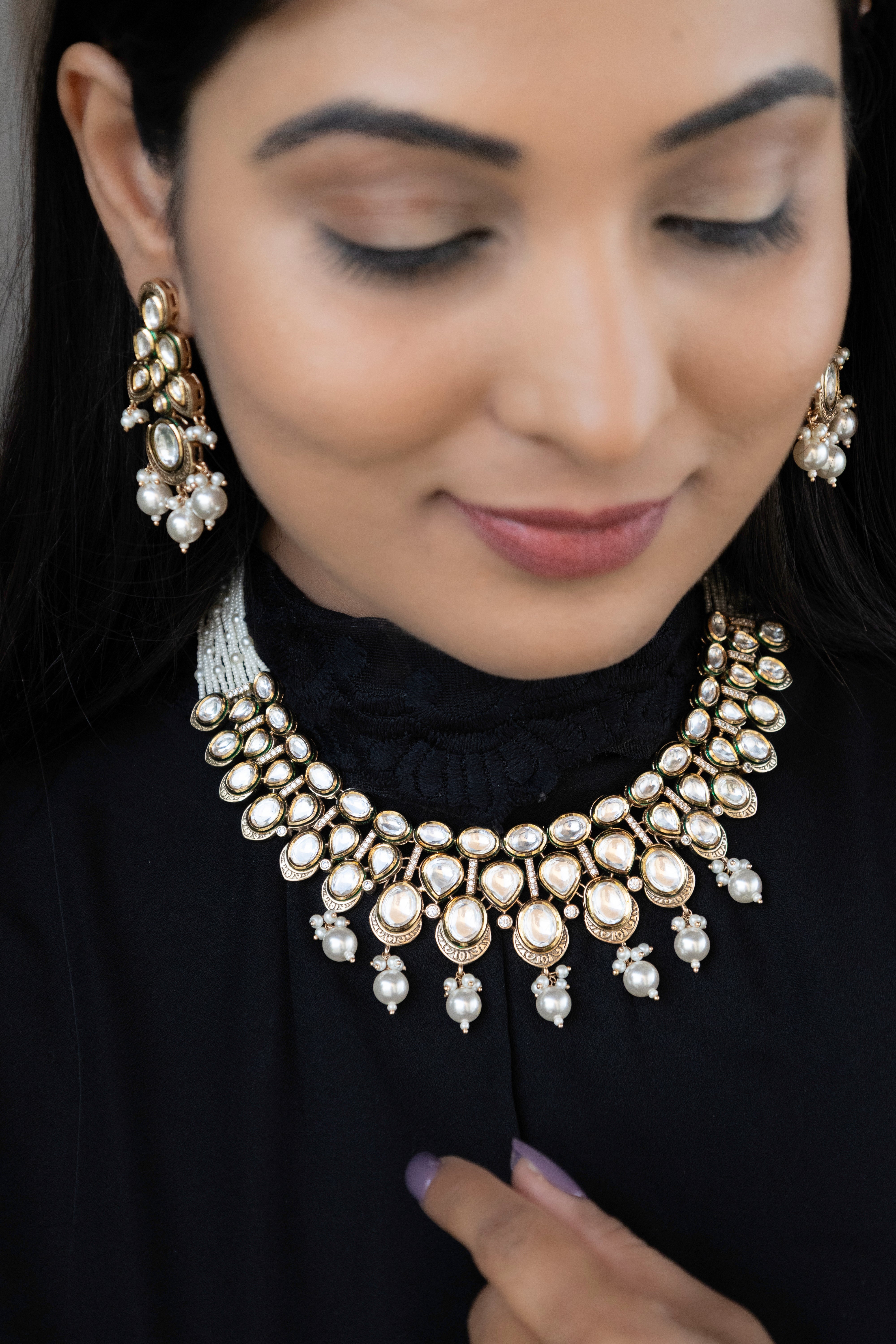 Polki stone necklace with pearl danglers and vintage gold finish, displayed frontally