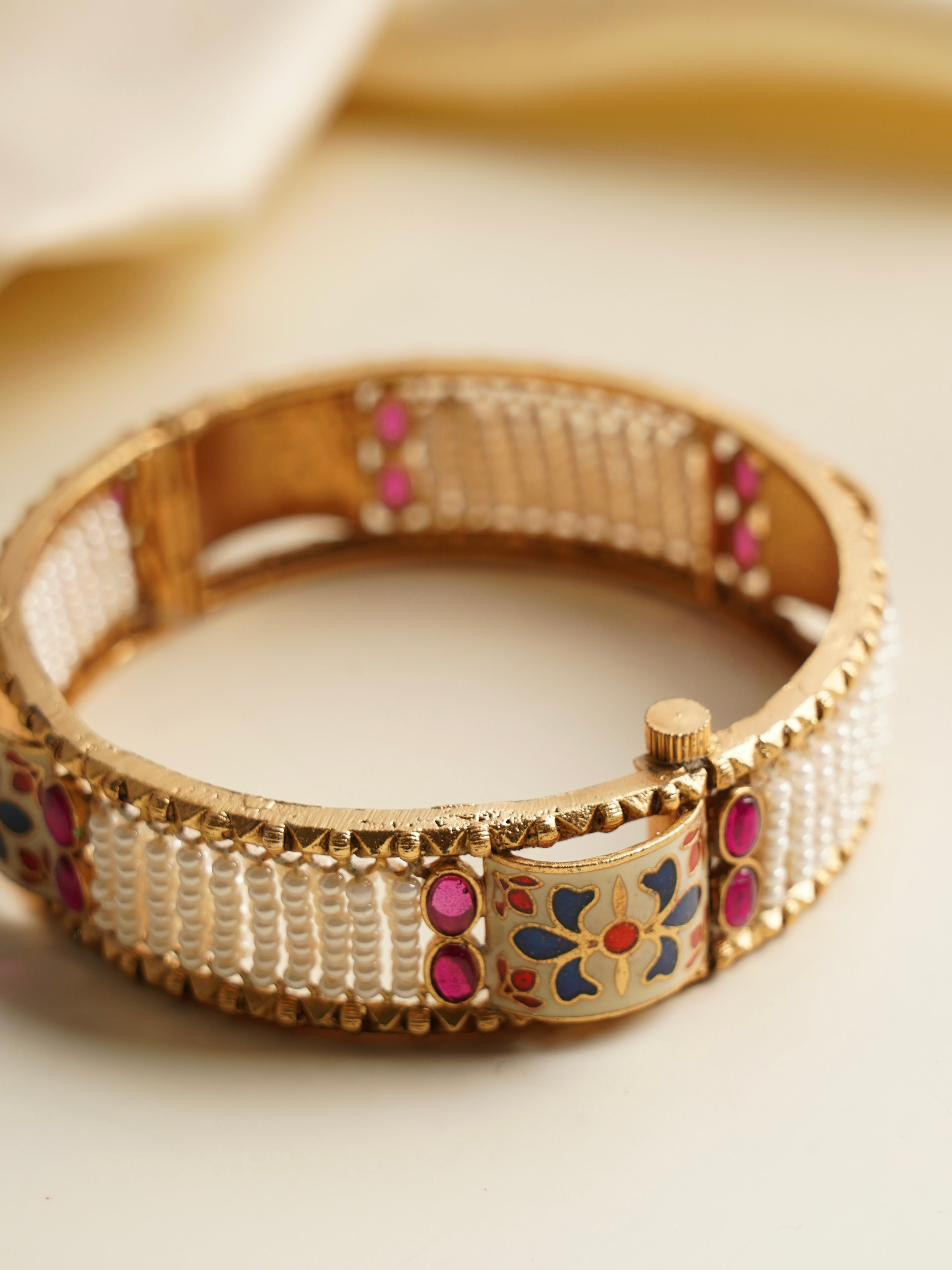 side profile of pearl and enamel bridal bangles with ruby highlights