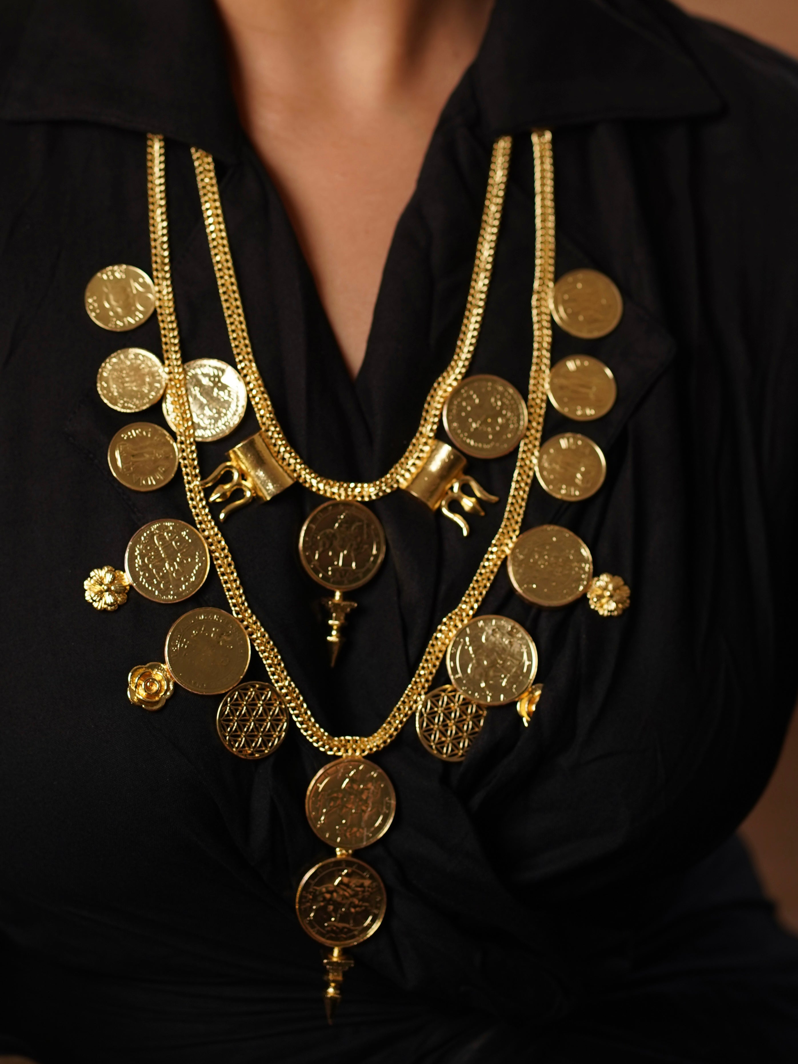 Close-up of Zyra necklace showing stacked coins and floral accents in micron gold plating