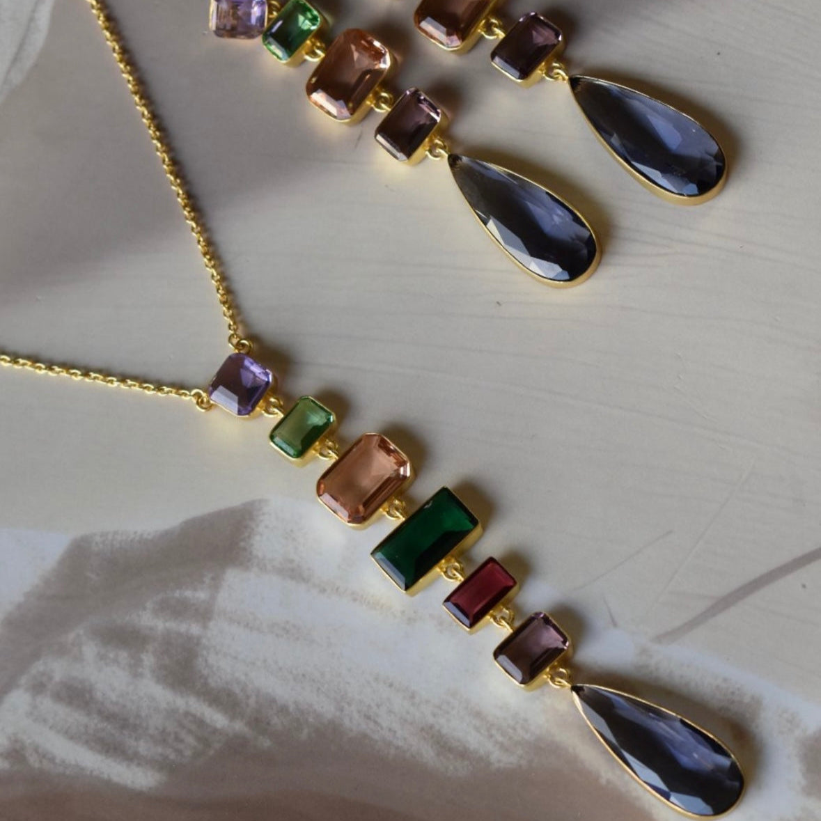 Flat lay of gemstone jewellery set with vibrant stones and matching earrings