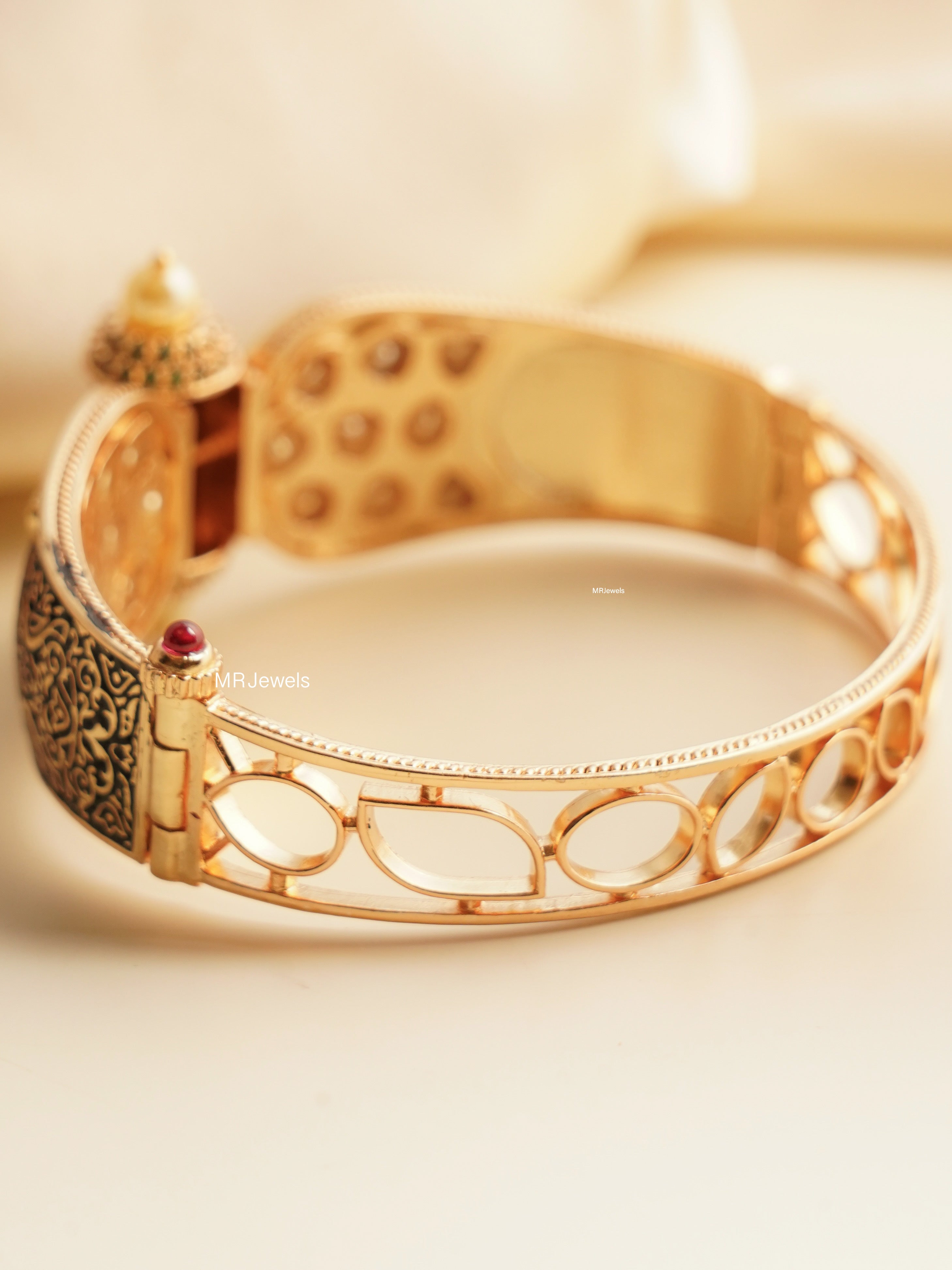 Detailed side view of ruby-embellished vintage gold bracelet with enamel and polki finish