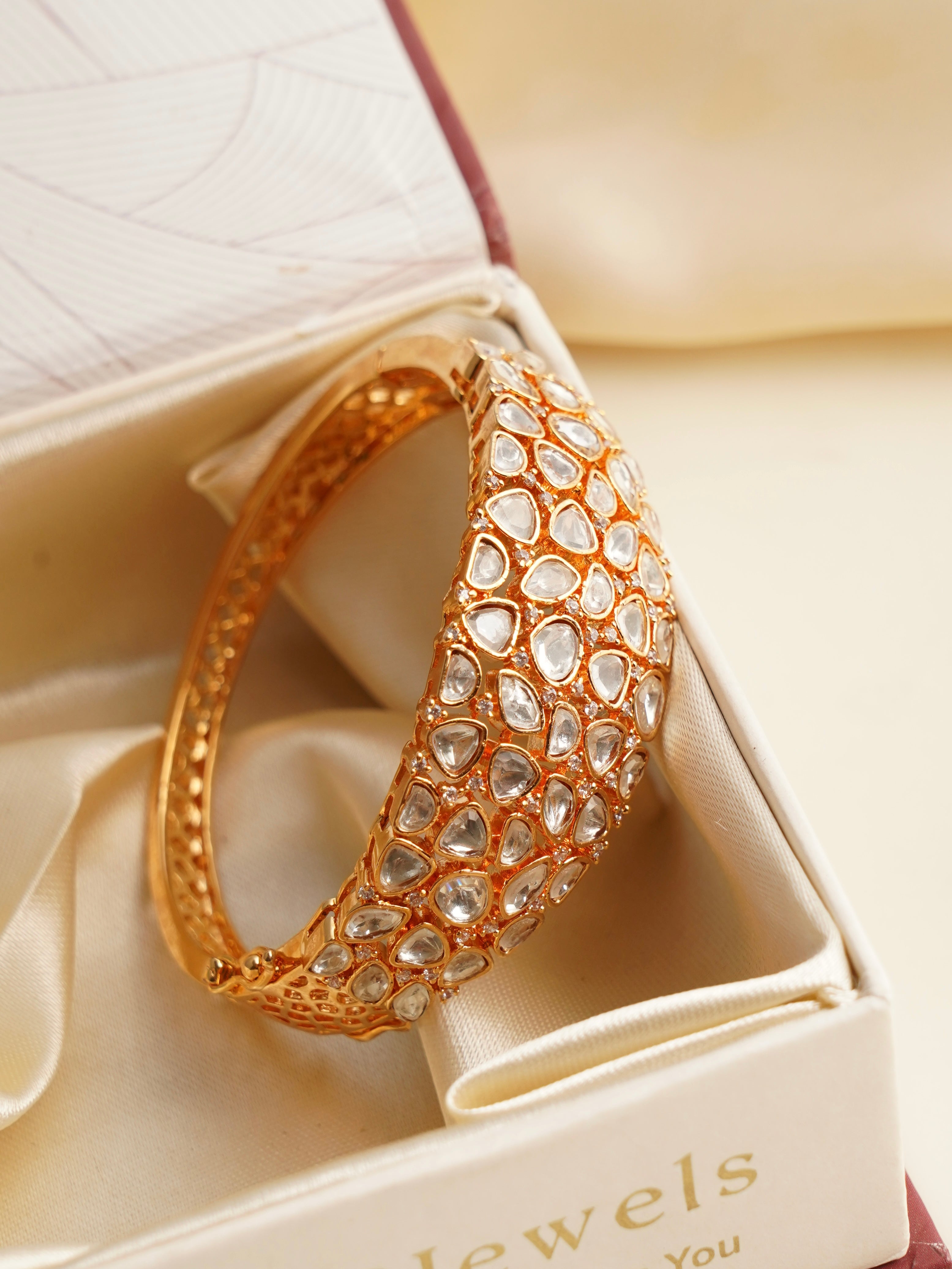 Angled view of kundan stone bracelet with gold-tone and intricate gem setting