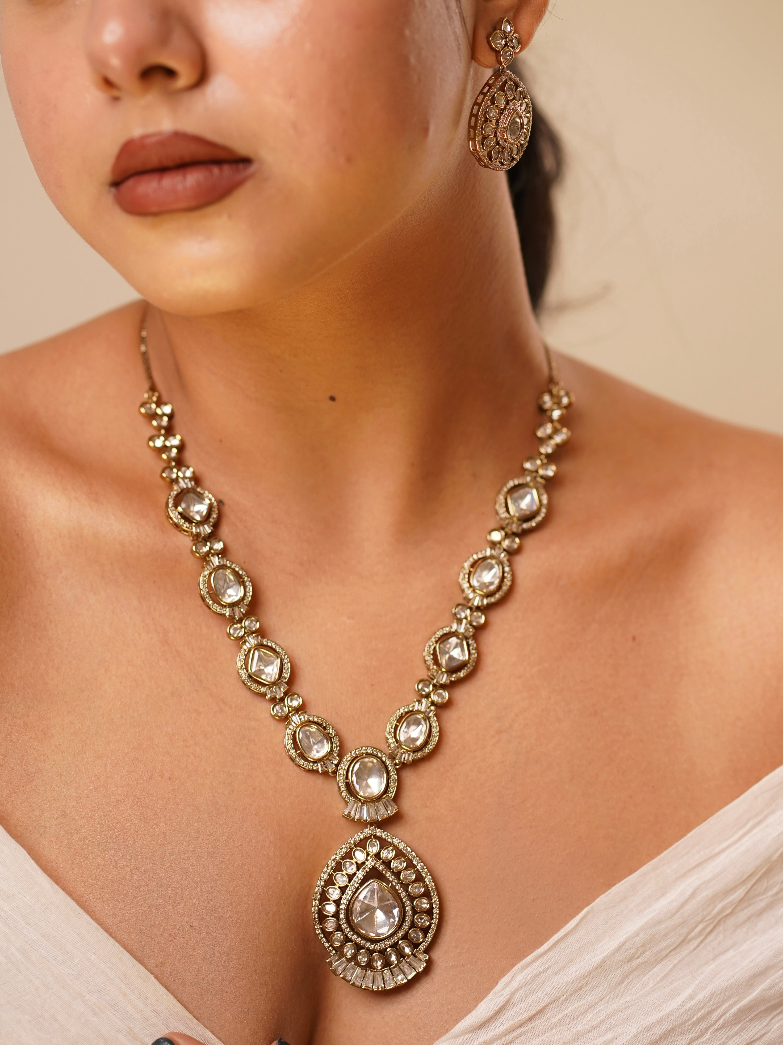 Teardrop kundan pendant necklace set with matching earrings and maang tikka in gold finish