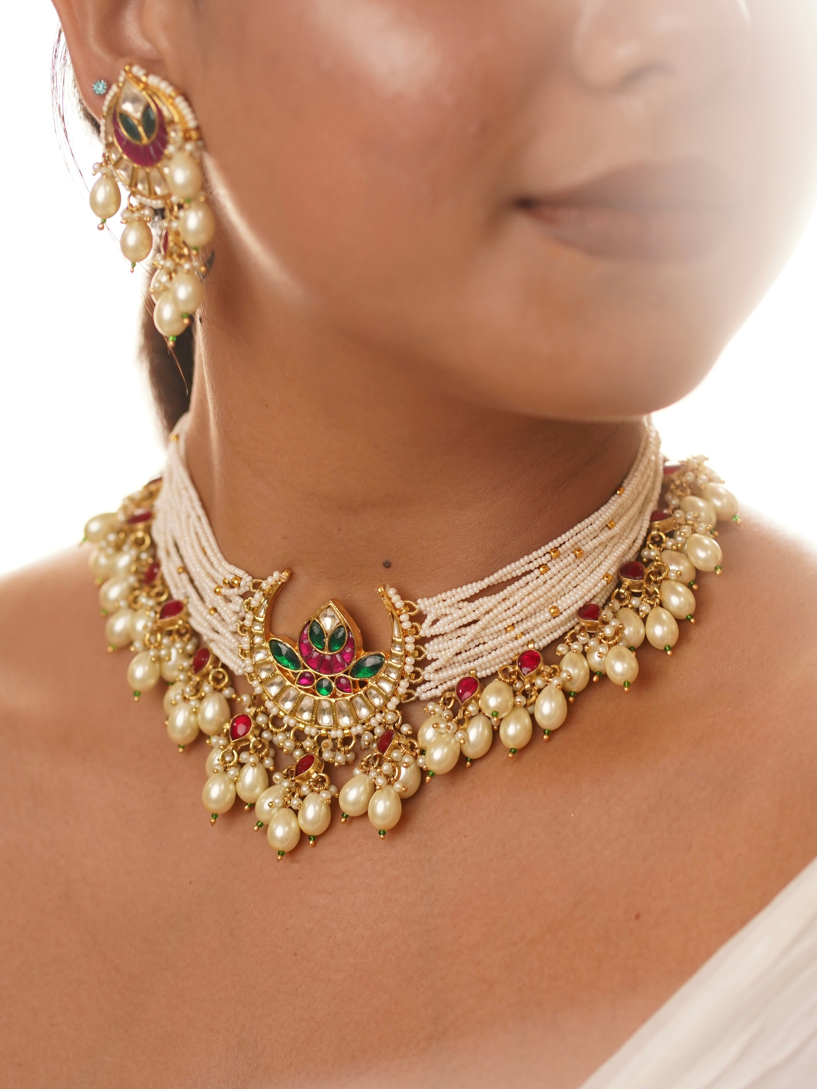 Close-up of choker pendant with meenakari work surrounded by pearl layers and kundan drops