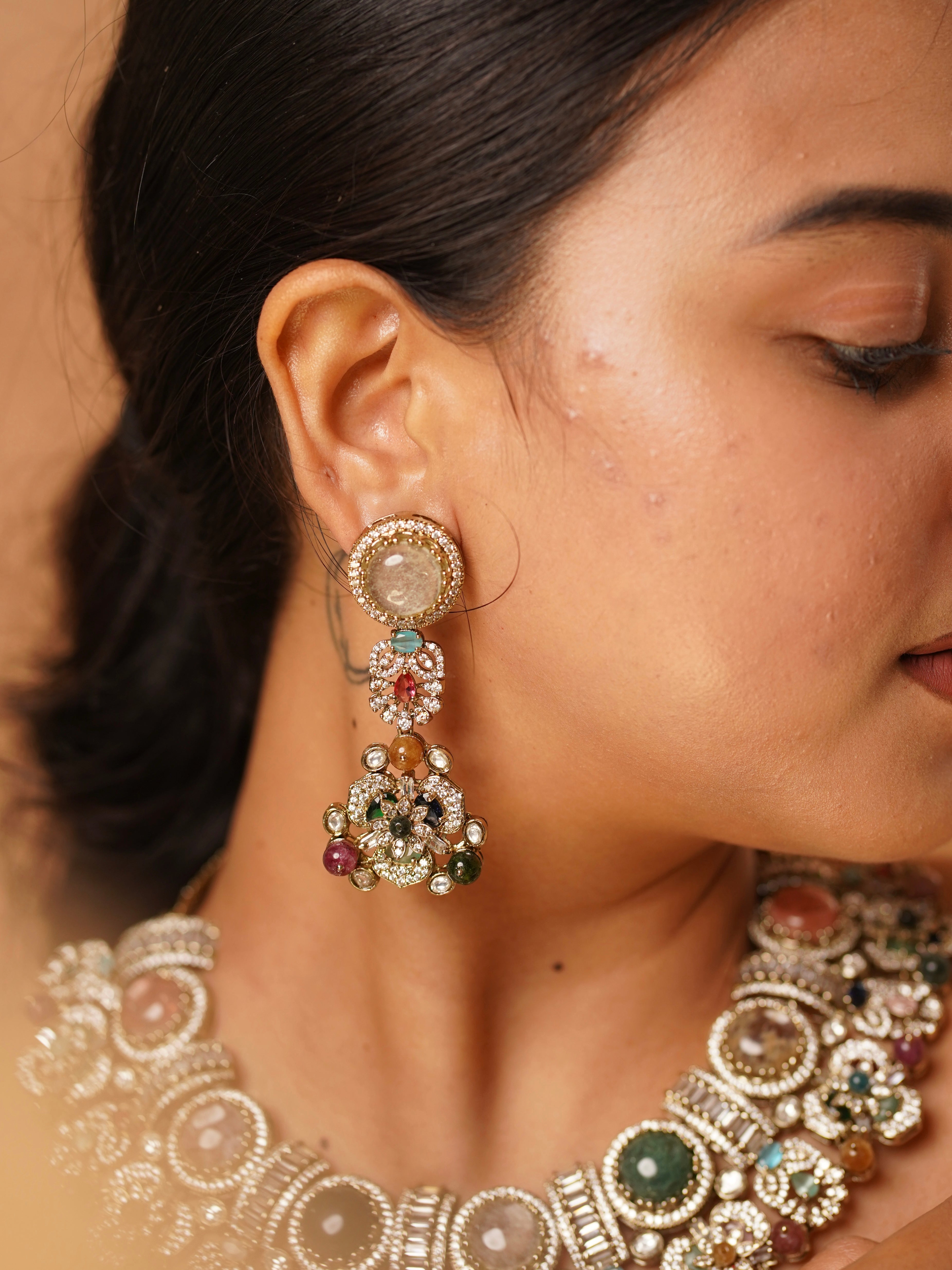 Detailed look at Sabya-style earrings with kundan-polki work and vibrant gemstone embellishments