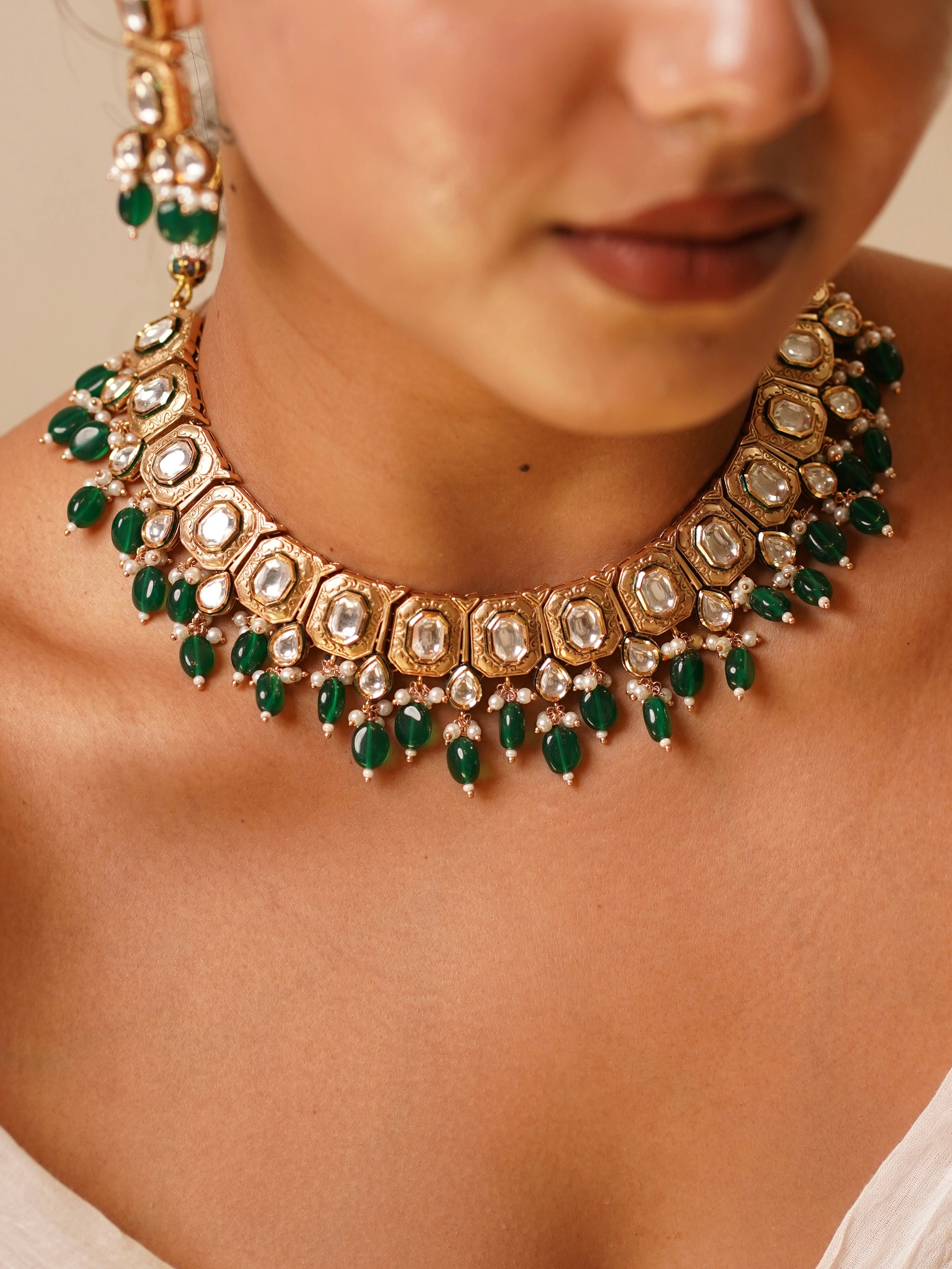 Close-up of Emera Kundan Royale choker with uncut kundan stones, antique gold frames and green bead fringe