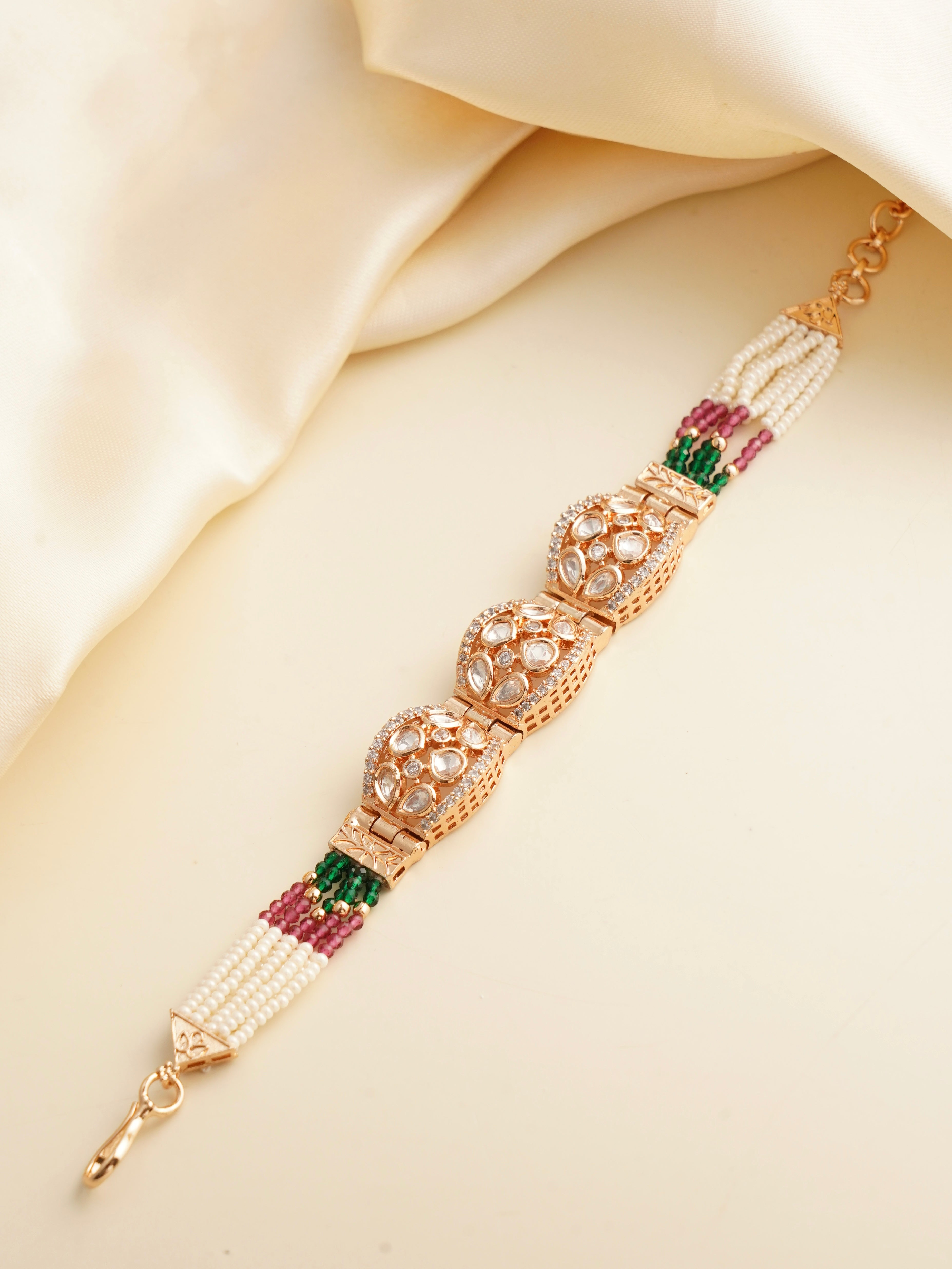 Top view of polki dome bracelet showcasing uncut stones, pearls and green‑pink bead strands