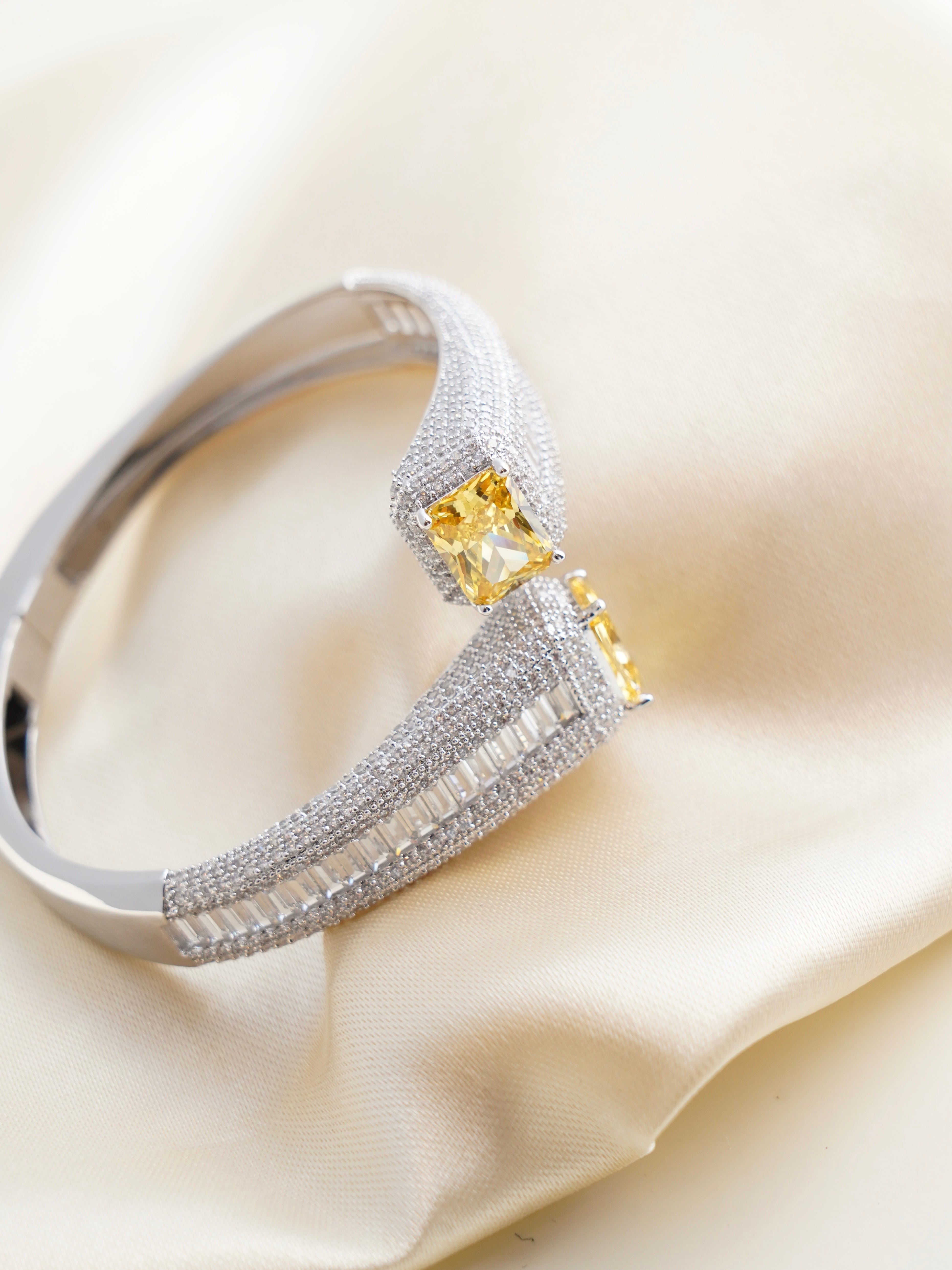 Stacked Celestia bracelets in pink, yellow, green, and blue with high-polish silver finish