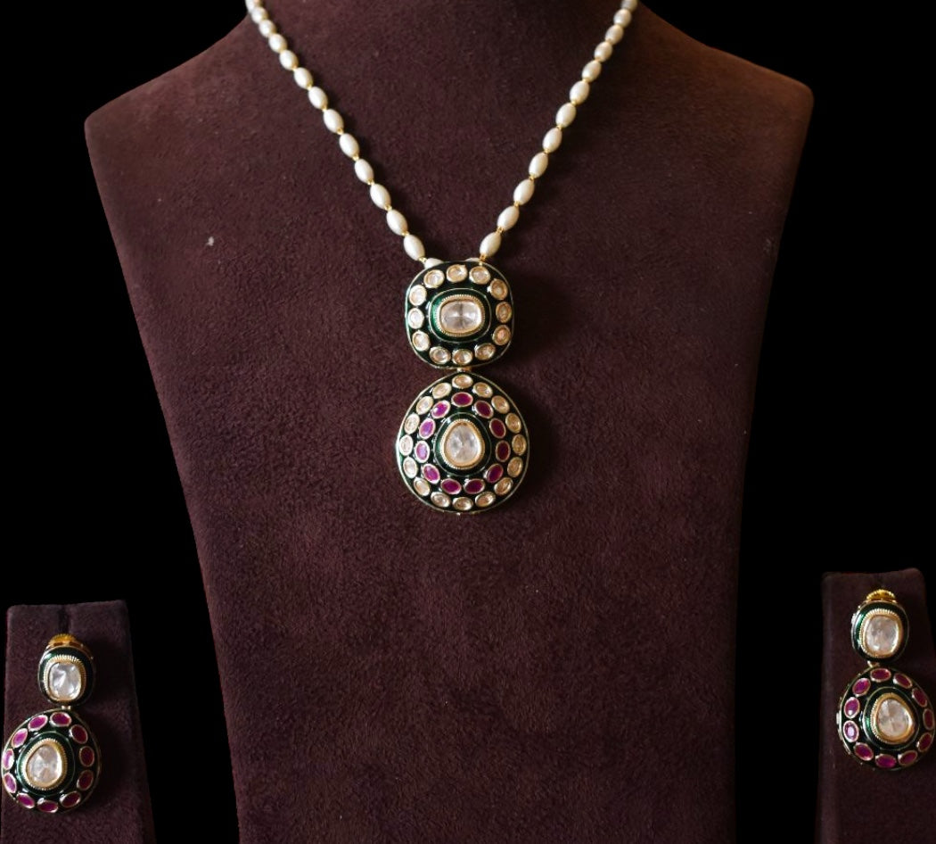 Angled view of Kiara kundan pendant with matching earrings and pearl detailing