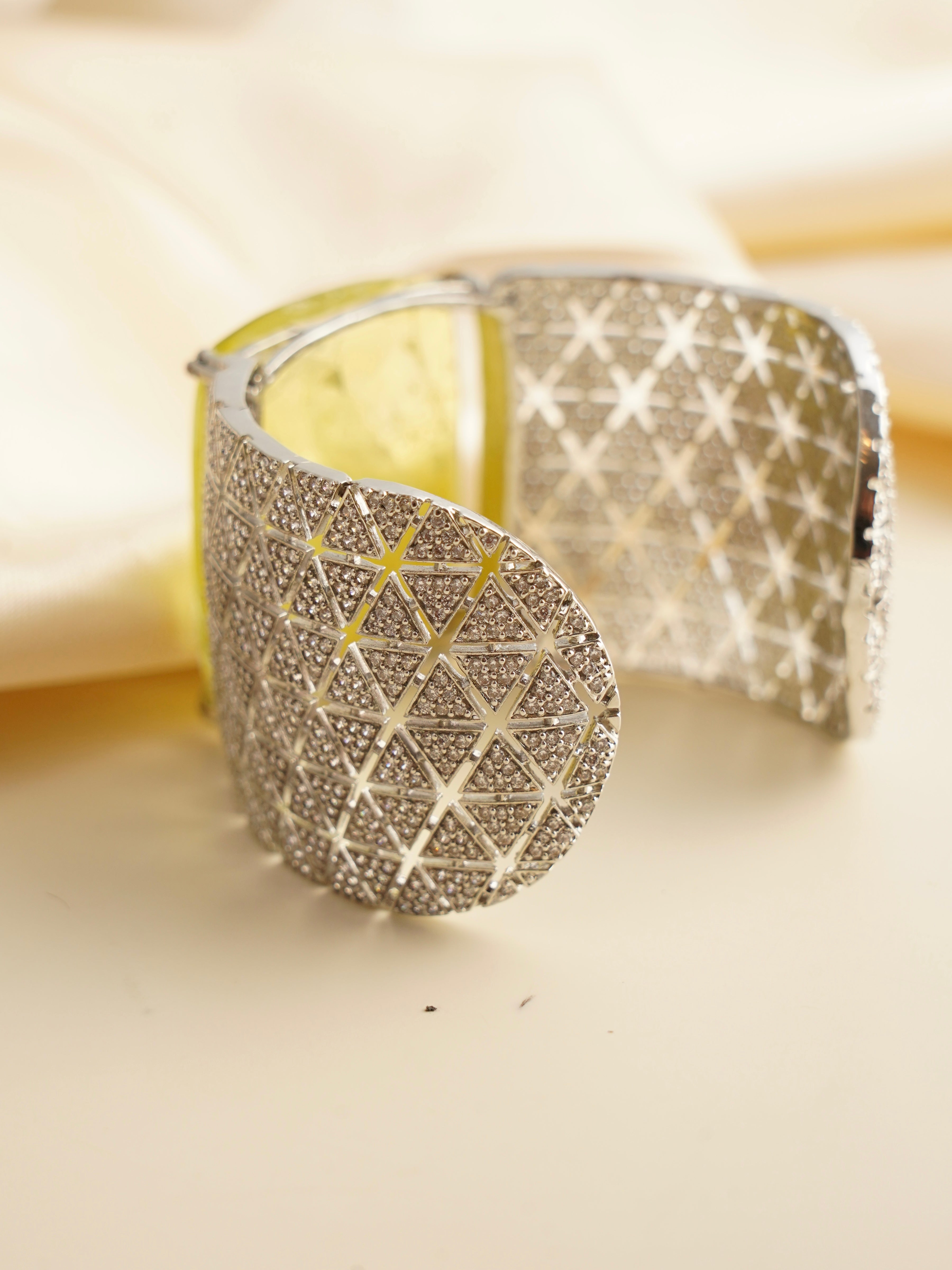 Detailed top view of luxury prism cuff bracelet in gold-tone finish with faceted stone