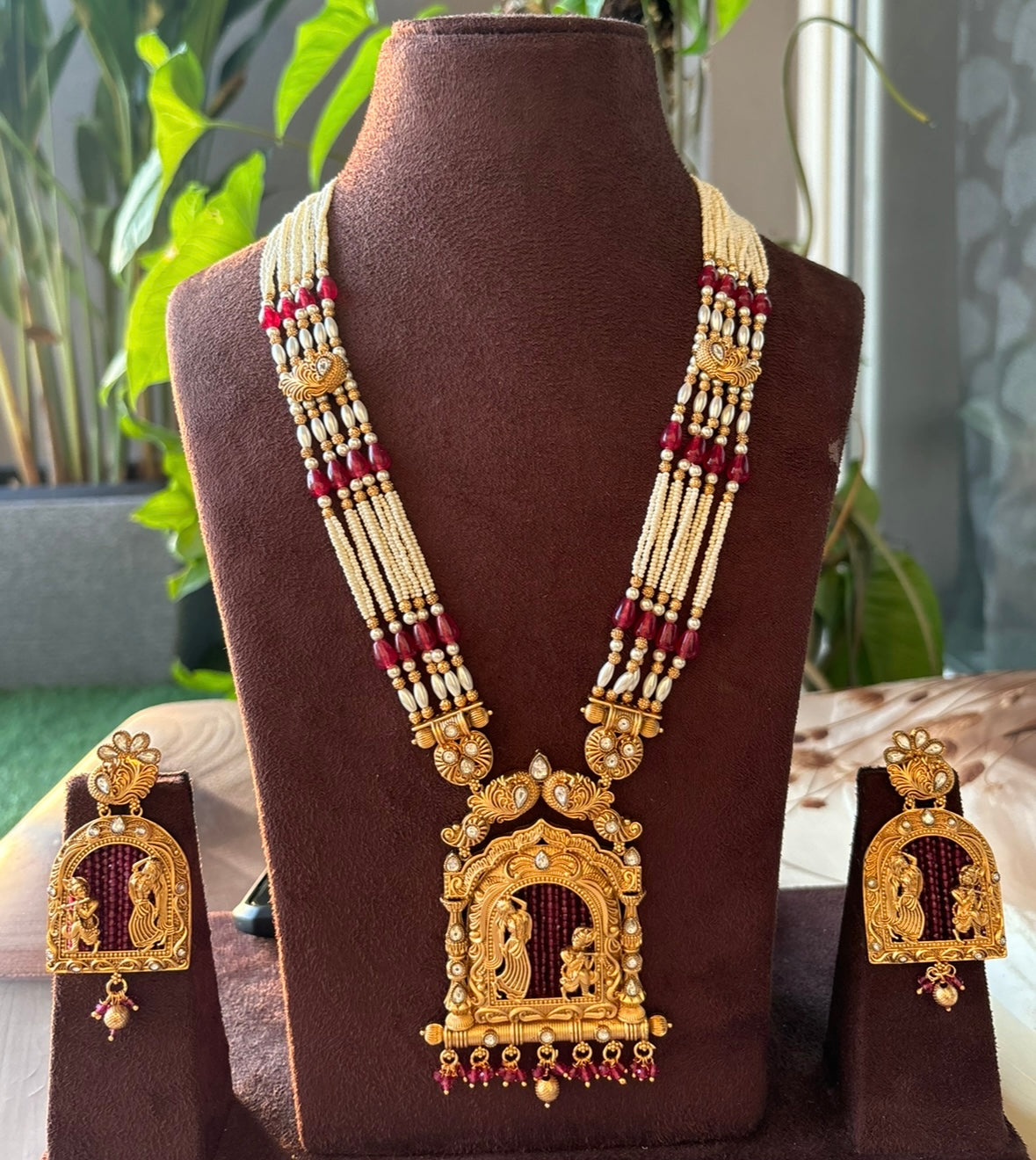 Angled close-up of divine necklace pendant featuring Radha Krishna with detailed metalwork