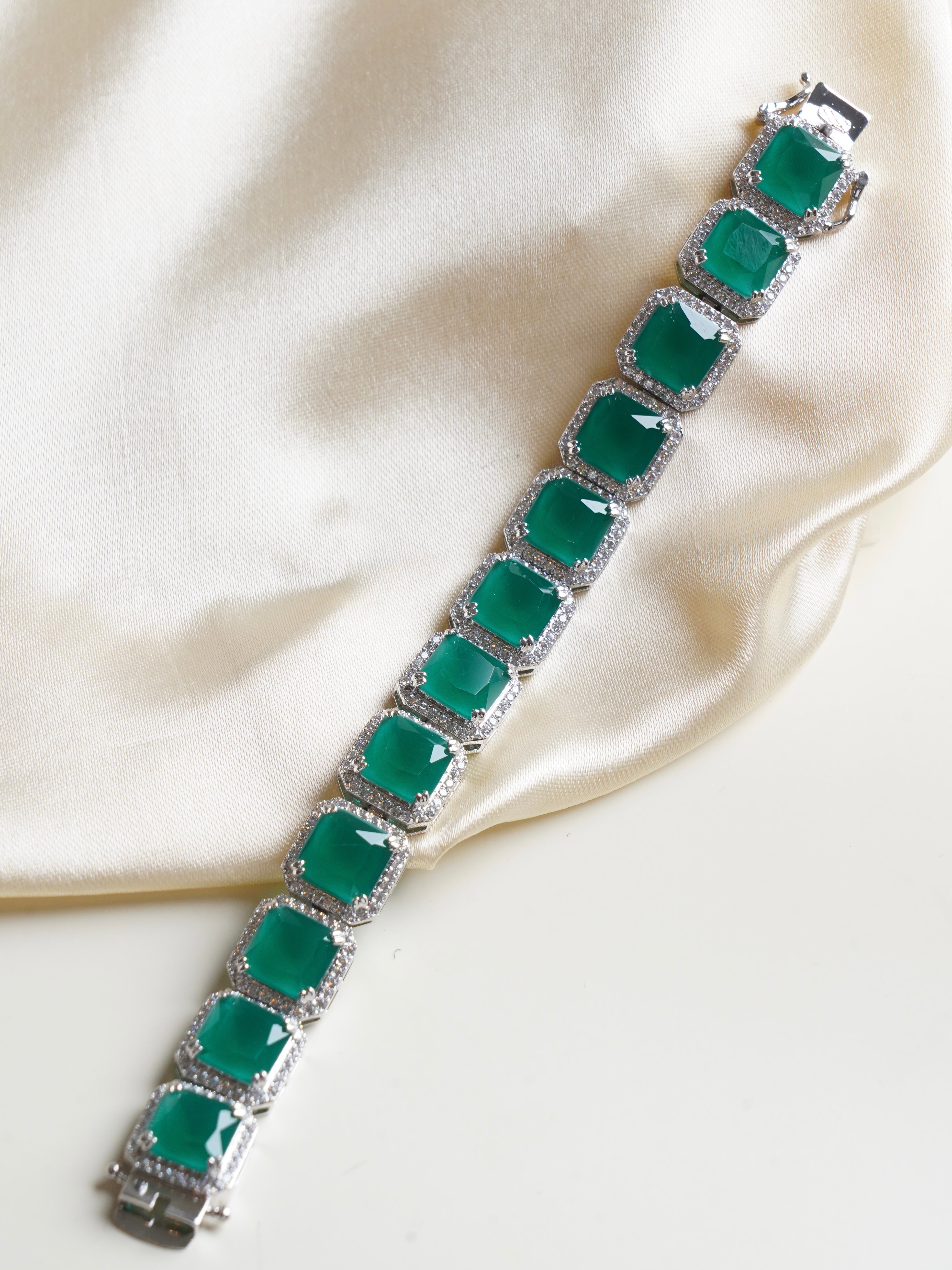 Emerald baguette bracelet with square green stones framed by baguette and round-cut crystal detailing