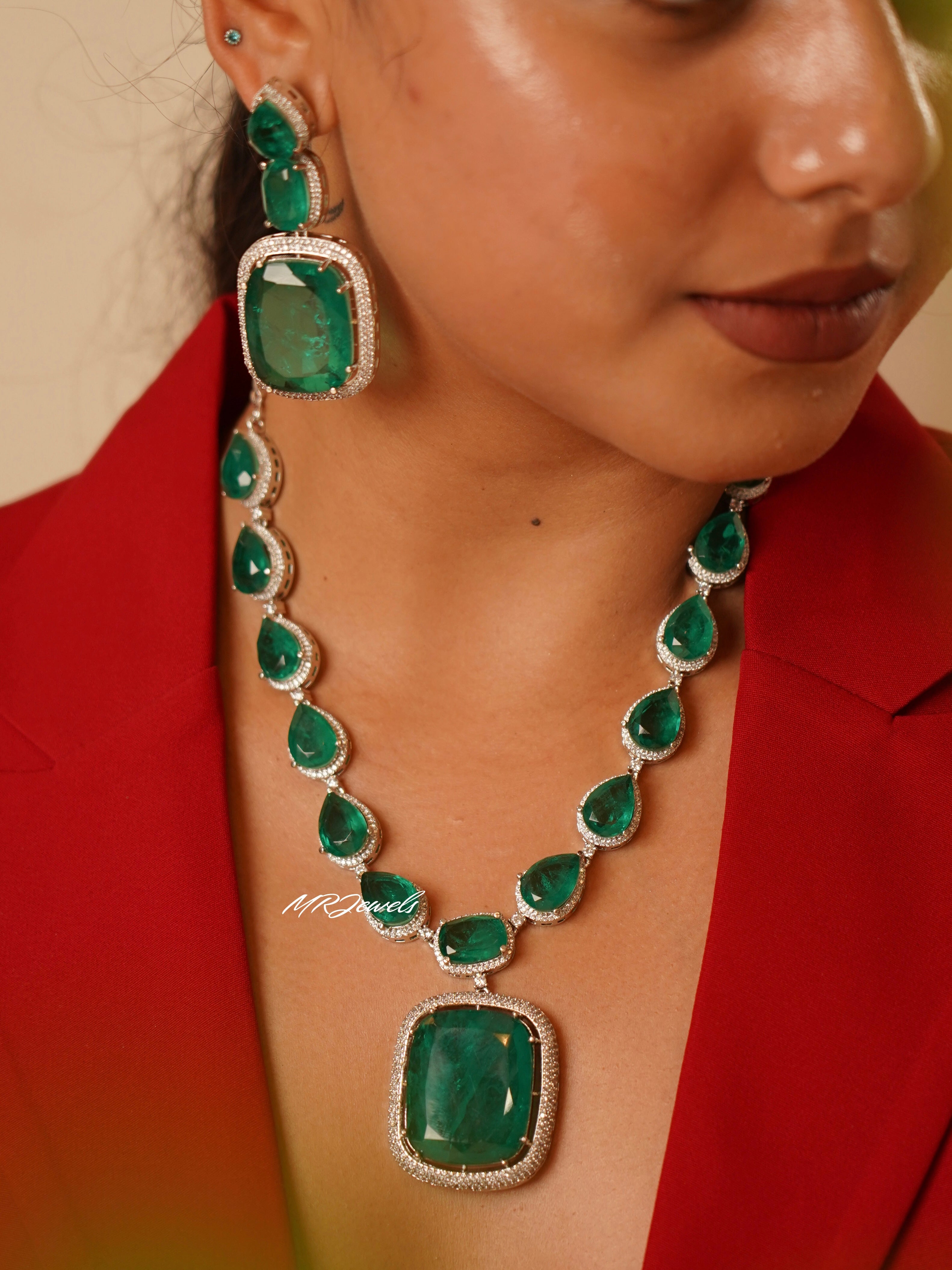 Heirloom emerald drop necklace with pear-shaped green stones and crystal halo centerpiece