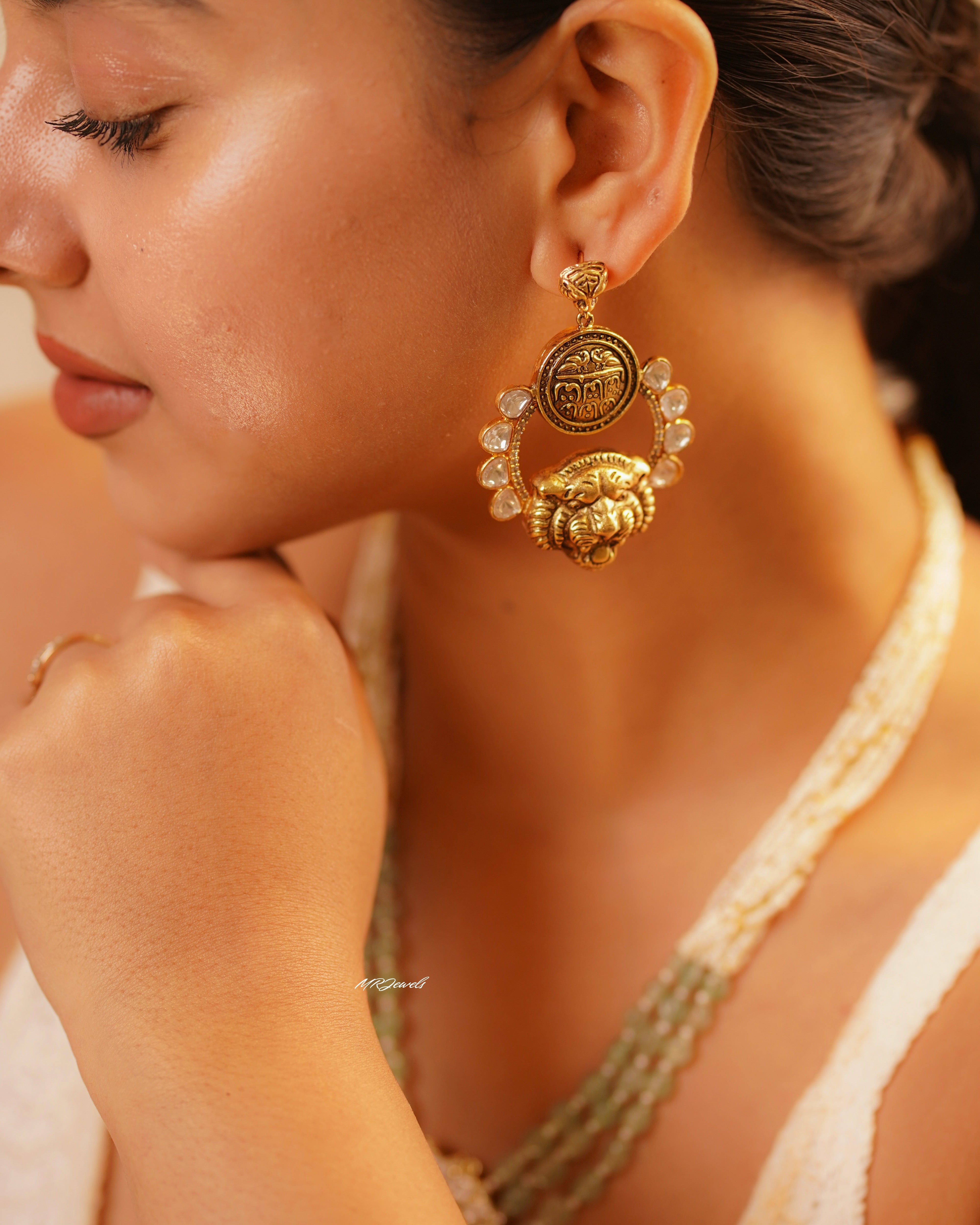 Necklace set close-up showing lion medallion pendant with kundan, pearls and green beads