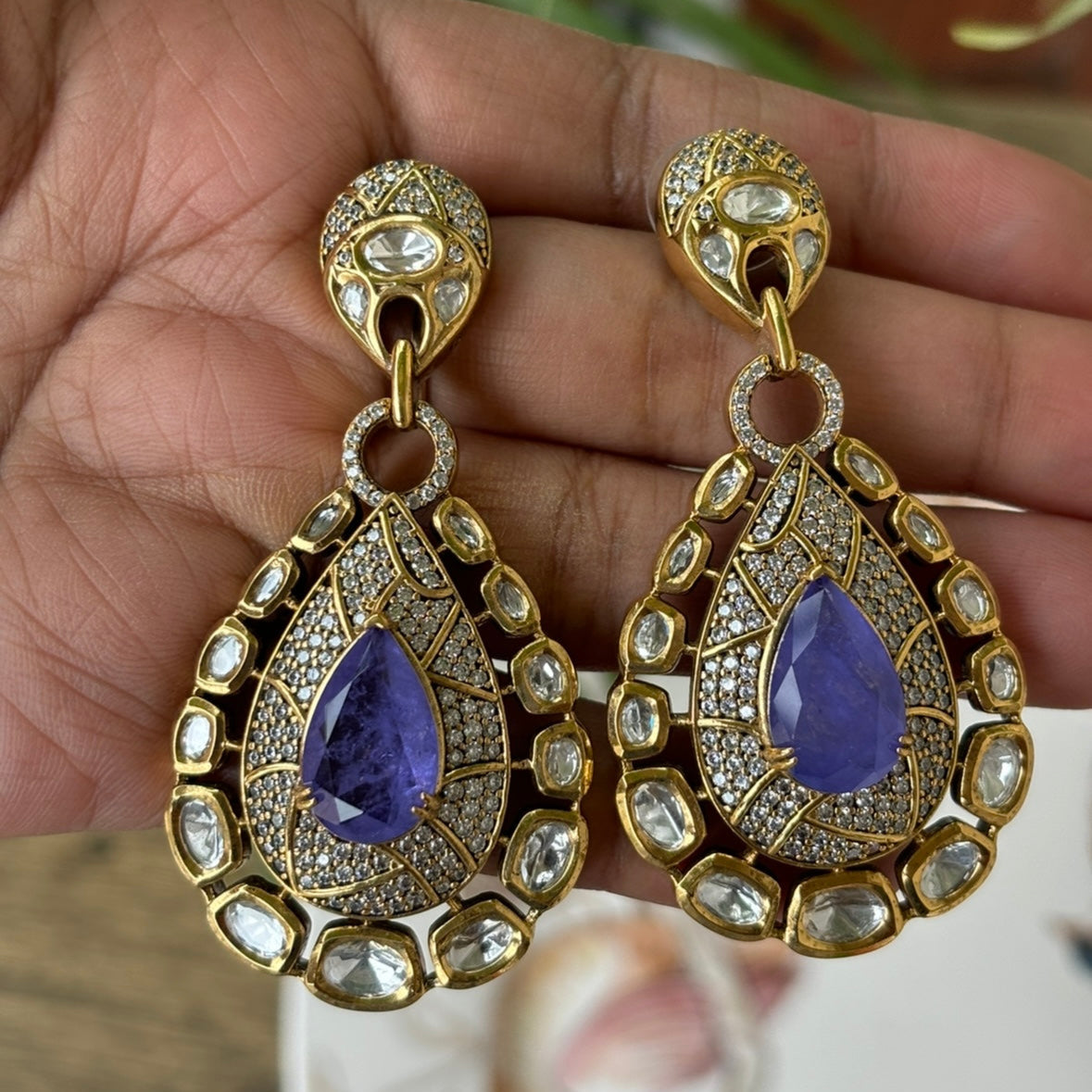 Side view of bold vintage earrings with gold-plated frame and emerald detailing