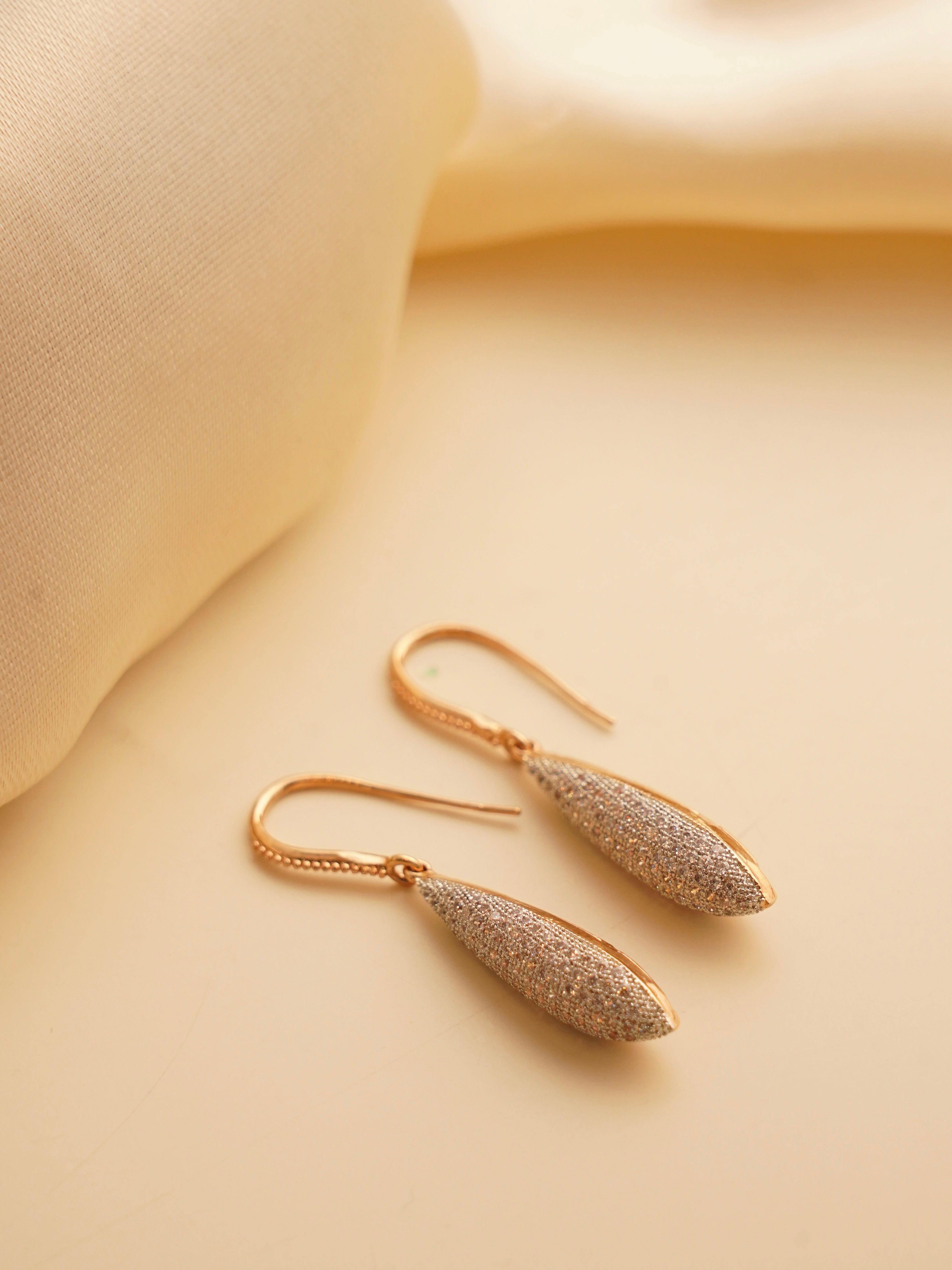 Diamond dust dangle earrings in rose gold with micro-pave zirconia and teardrop silhouette