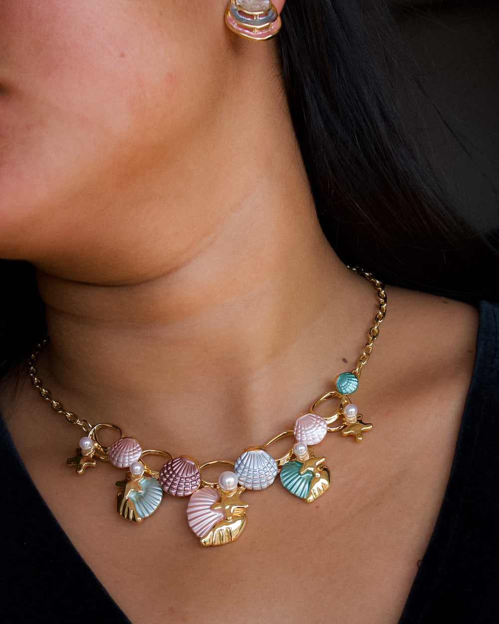 Seashell-inspired necklace set with enamel charms, starfish details, and pearl highlights