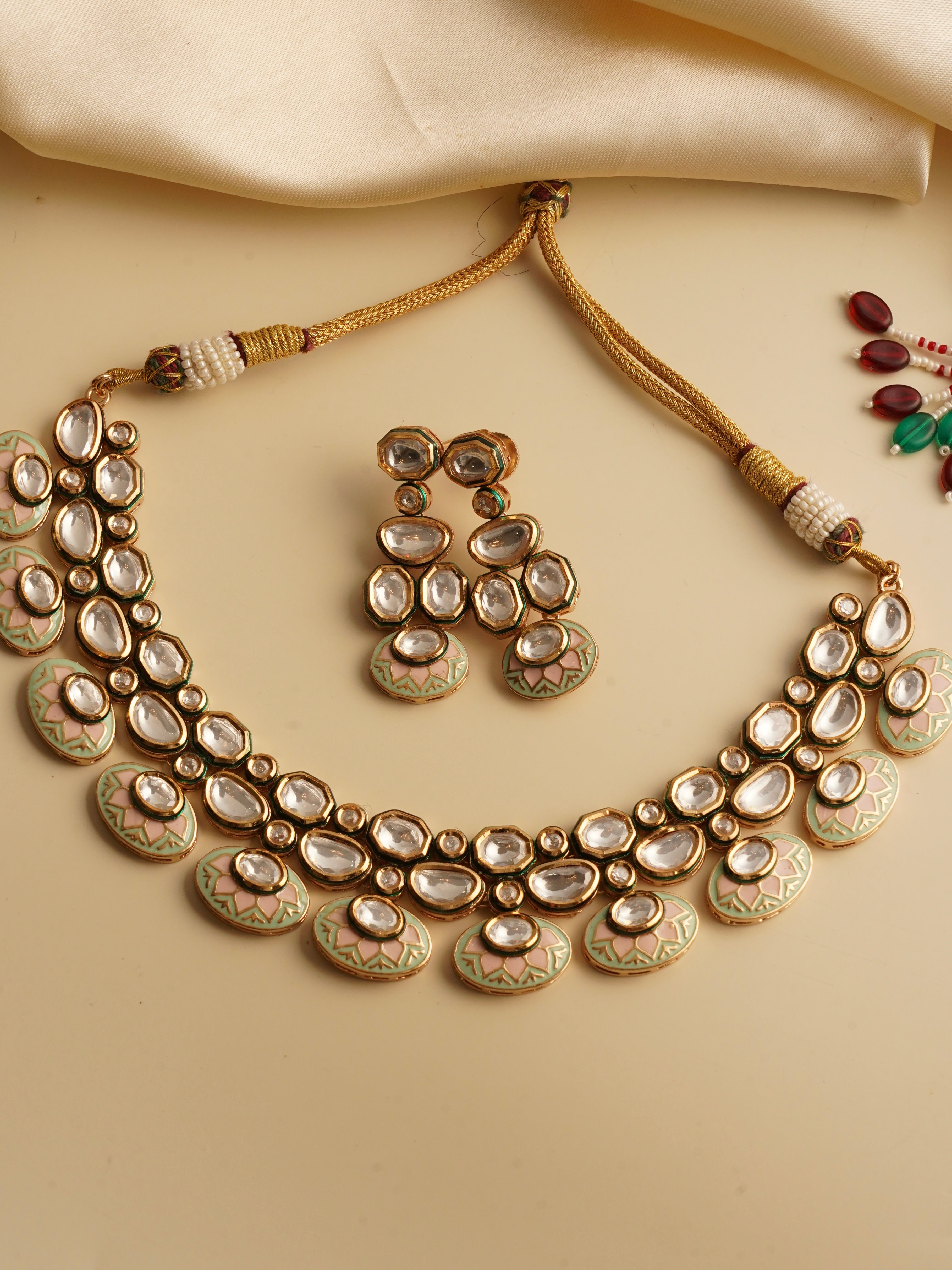 Matching earrings from rajwada kundan set with gold finish and red meenakari accents