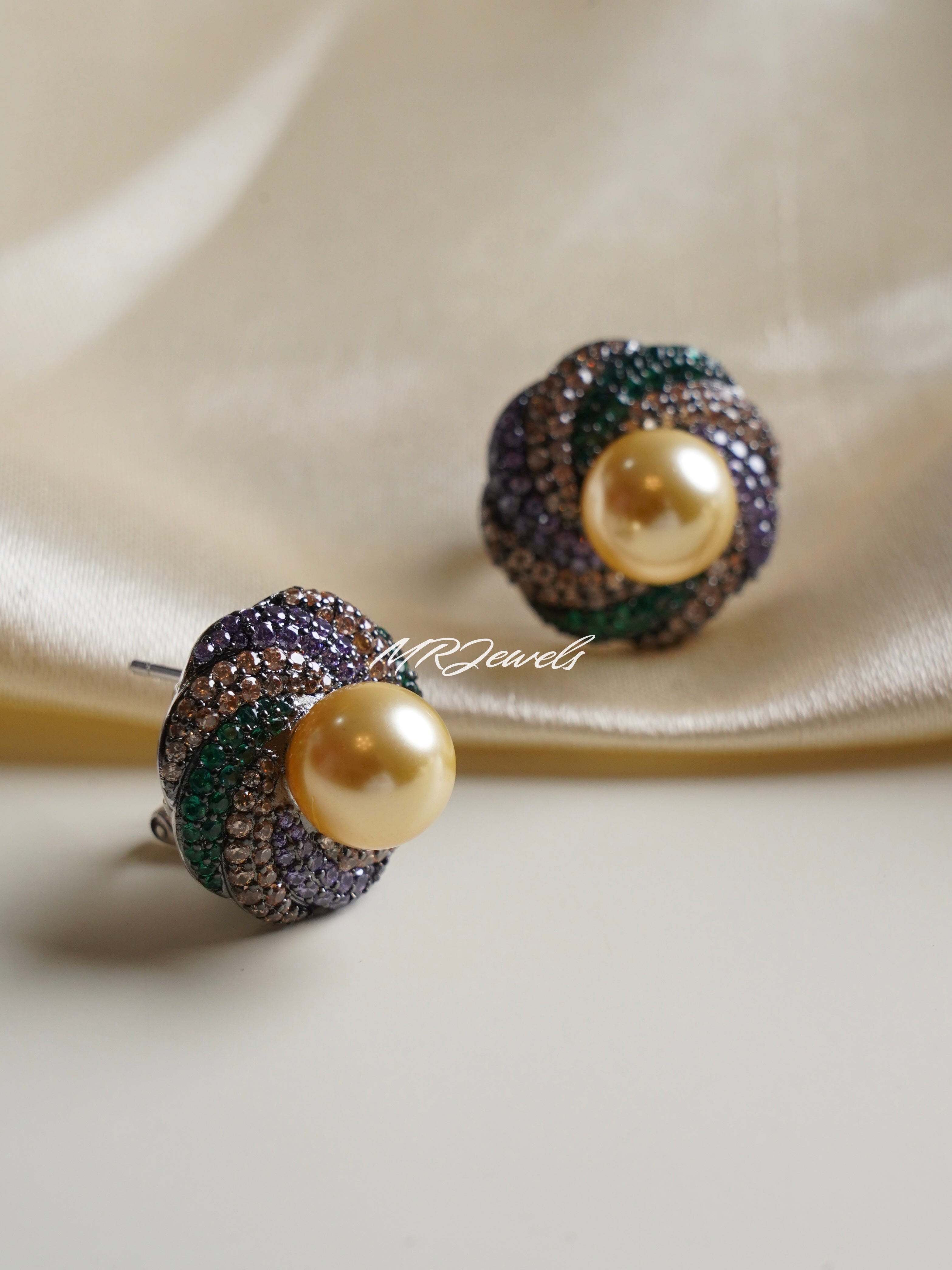 Side view of pearl dome earrings showcasing raised golden pearl and studded colourful crystal base