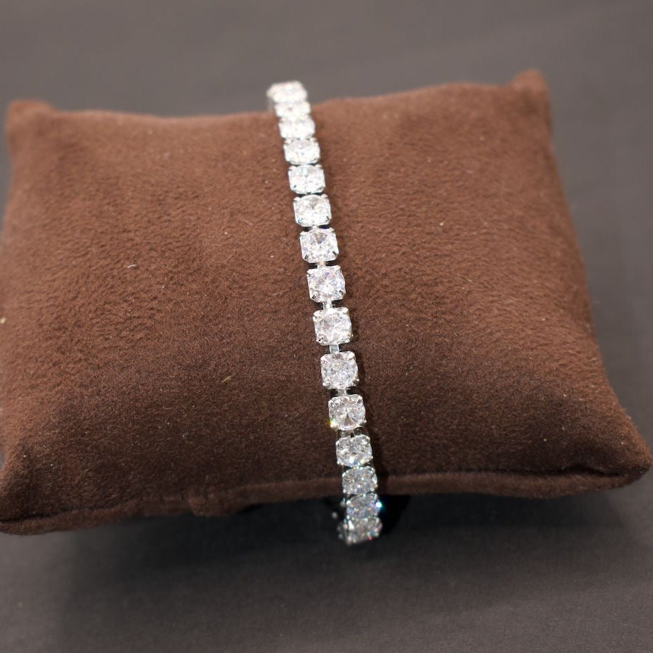 Side angle of diamond tennis bracelet showing clasp and continuous stone layout