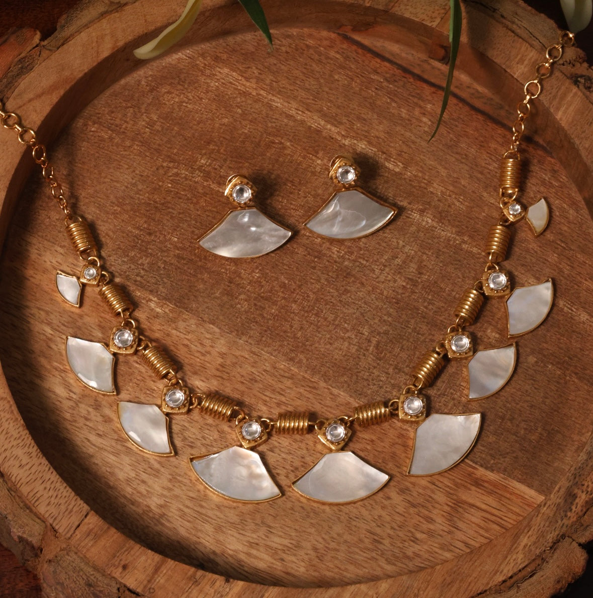 Close-up of necklace chain links and multitone crystals on fan-inspired motifs