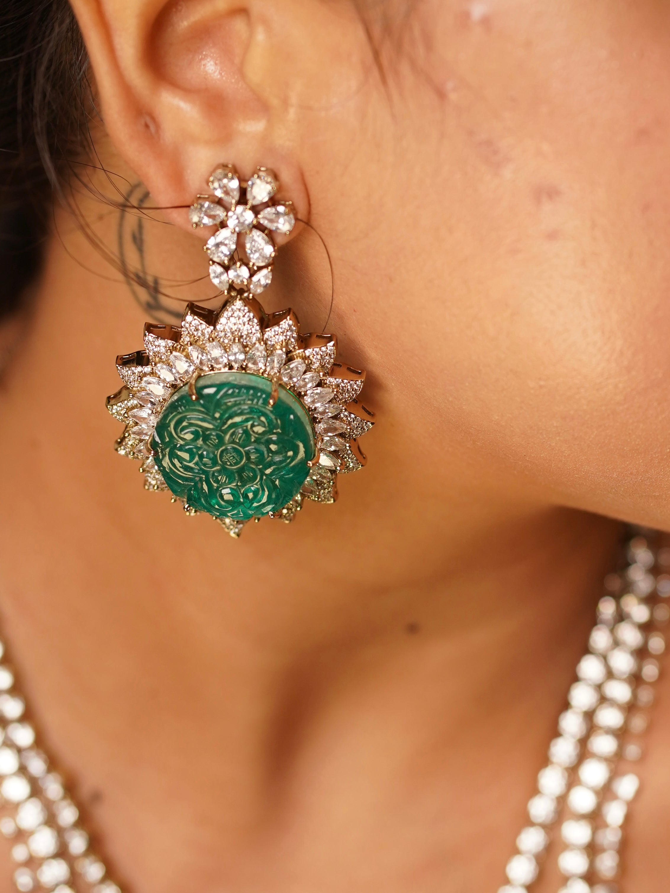 Close-up of emerald-elan necklace showing hand-carved green medallion with cubic zirconia burst accents