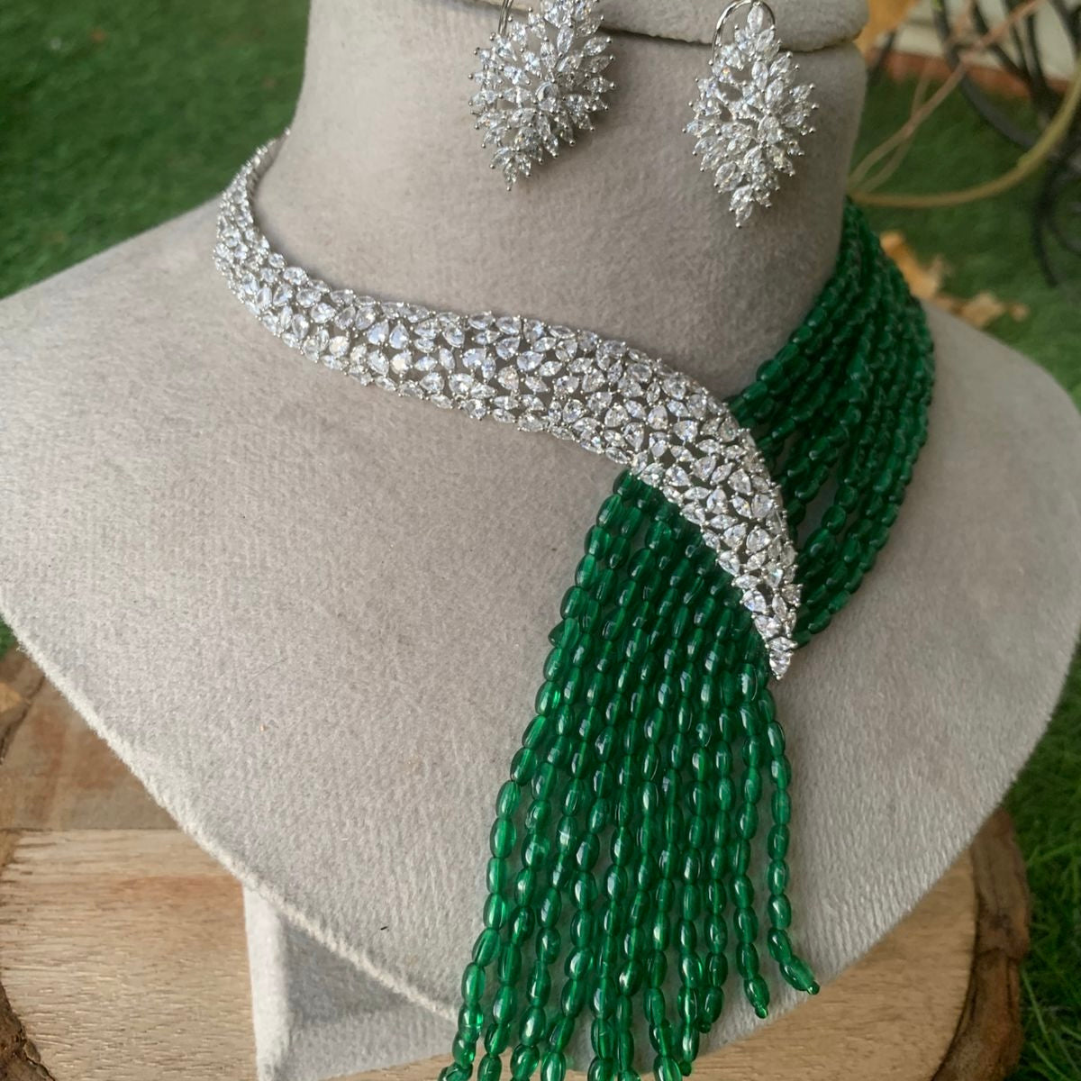 Close-up of diamond necklace set featuring glittering stonework and deep red beaded layers
