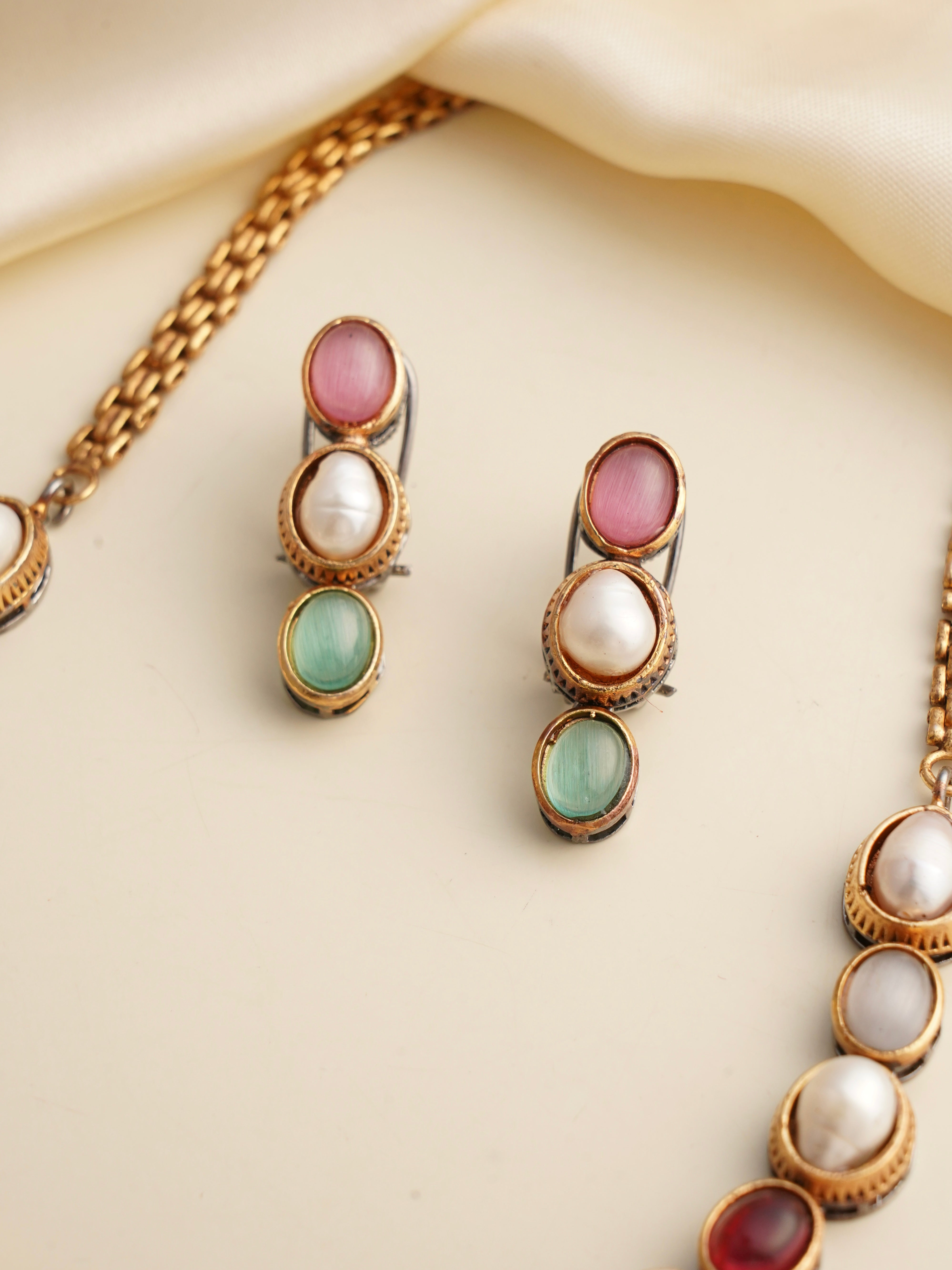 Minimal luxe gemstone necklace with close-up on textured natural stones and metallic detailing