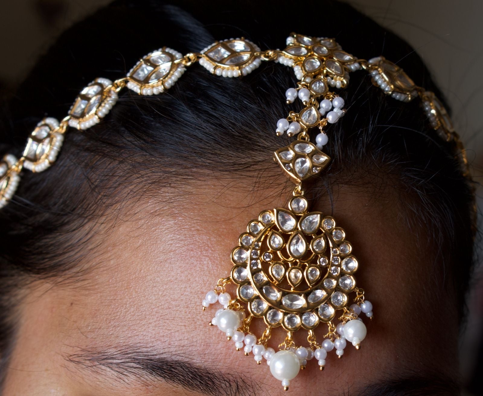Kundan maang tikka with floral detailing and layered pearl embellishments
