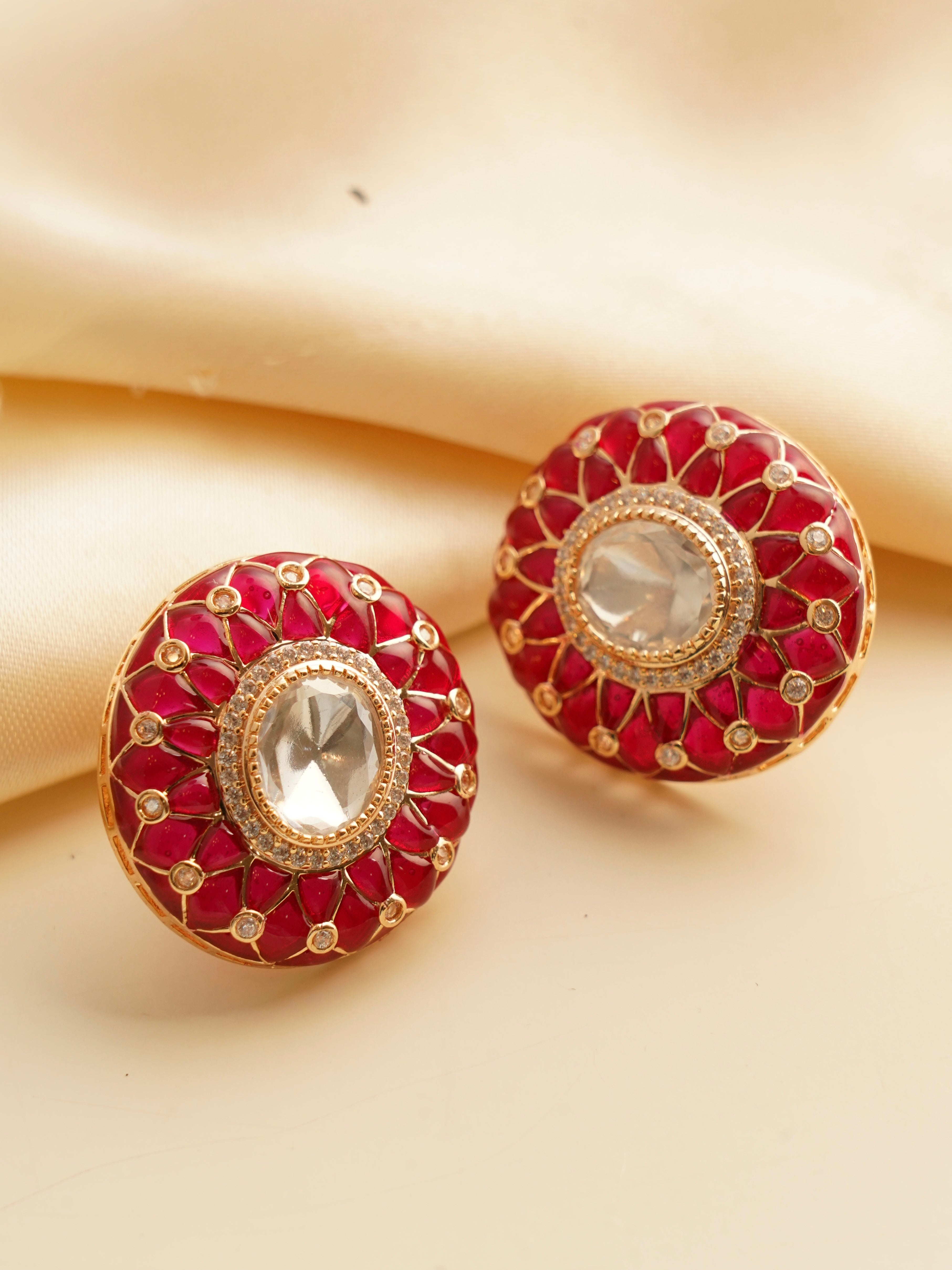 Floral-inspired earrings with red enamel, white stones, and gold-tone detailing, front view