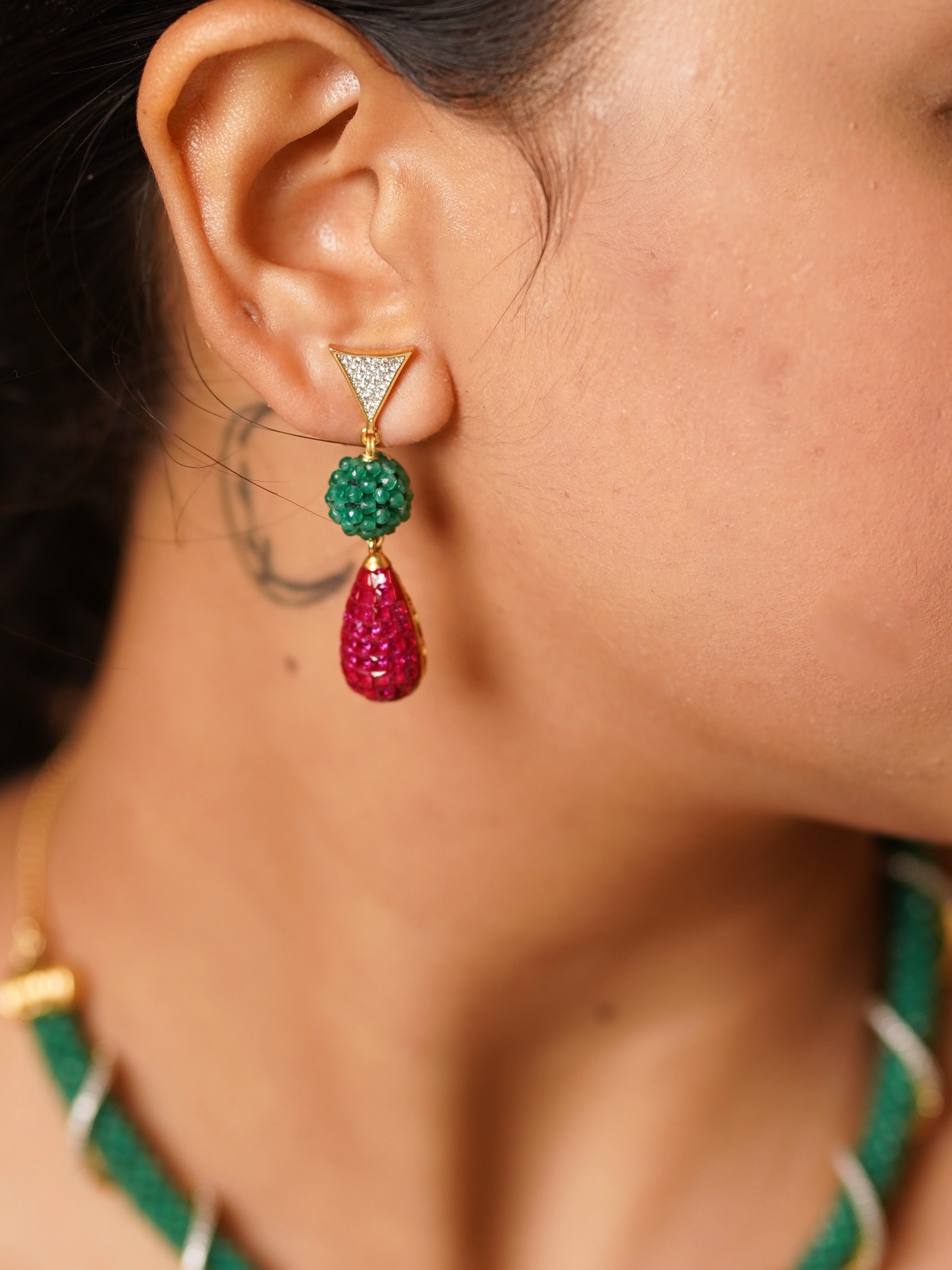 Close-up of hasli necklace highlighting ruby drop, green braiding, and ornate setting