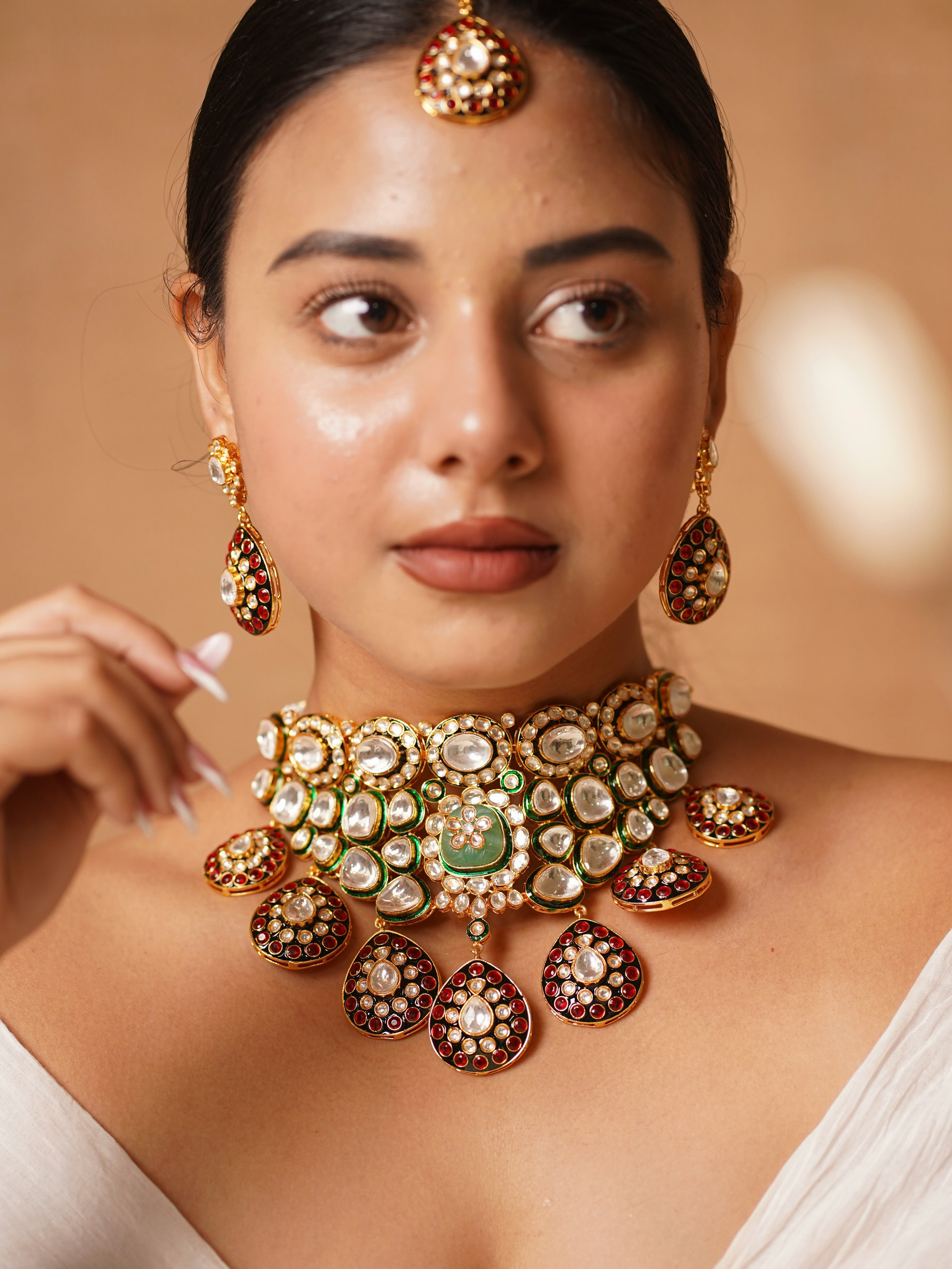 Front view of polki necklace set with ruby stones, kundan details and matching earrings