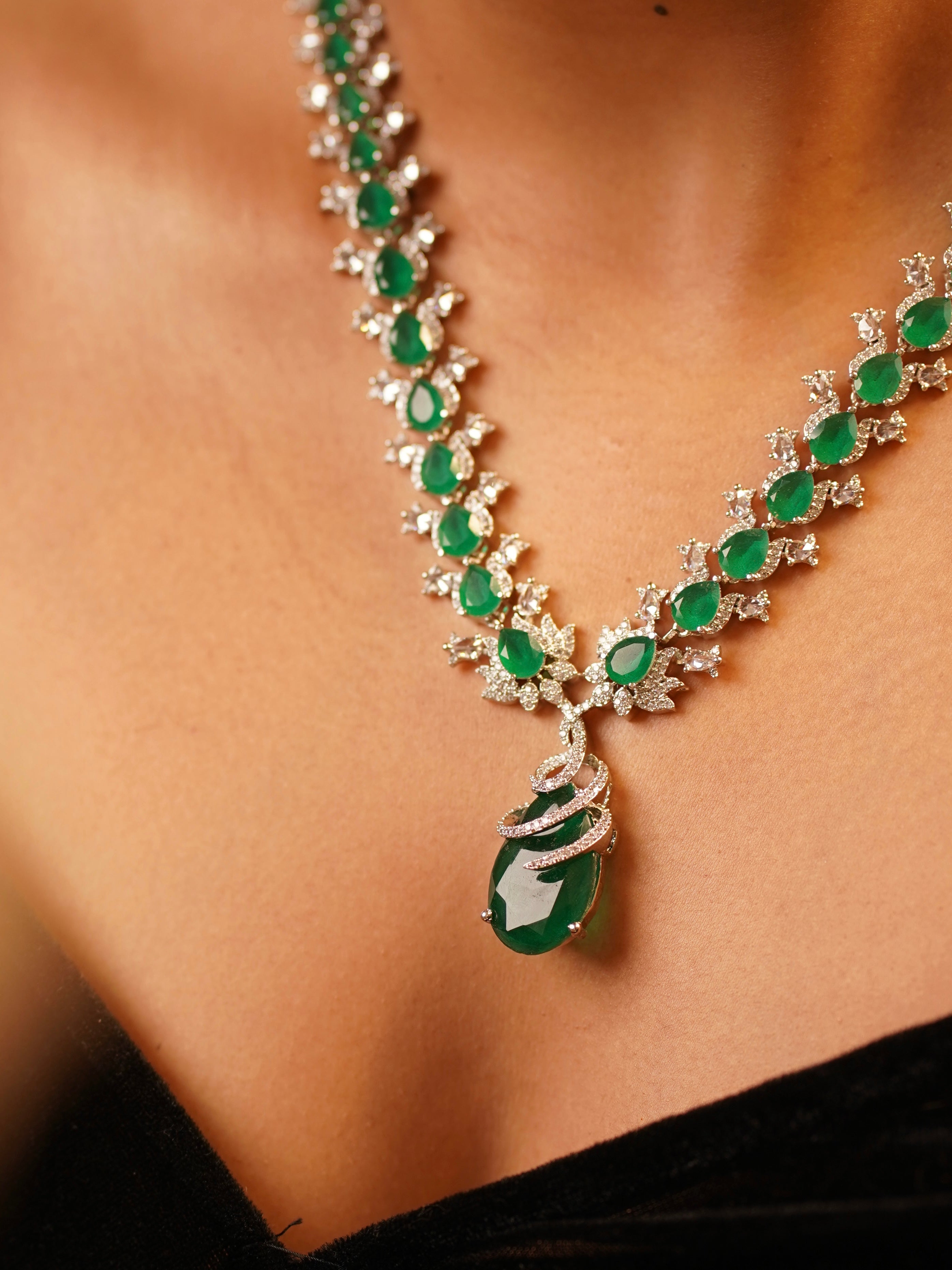 side view of ruby diamond necklace with detailed stone arrangement and matching earrings