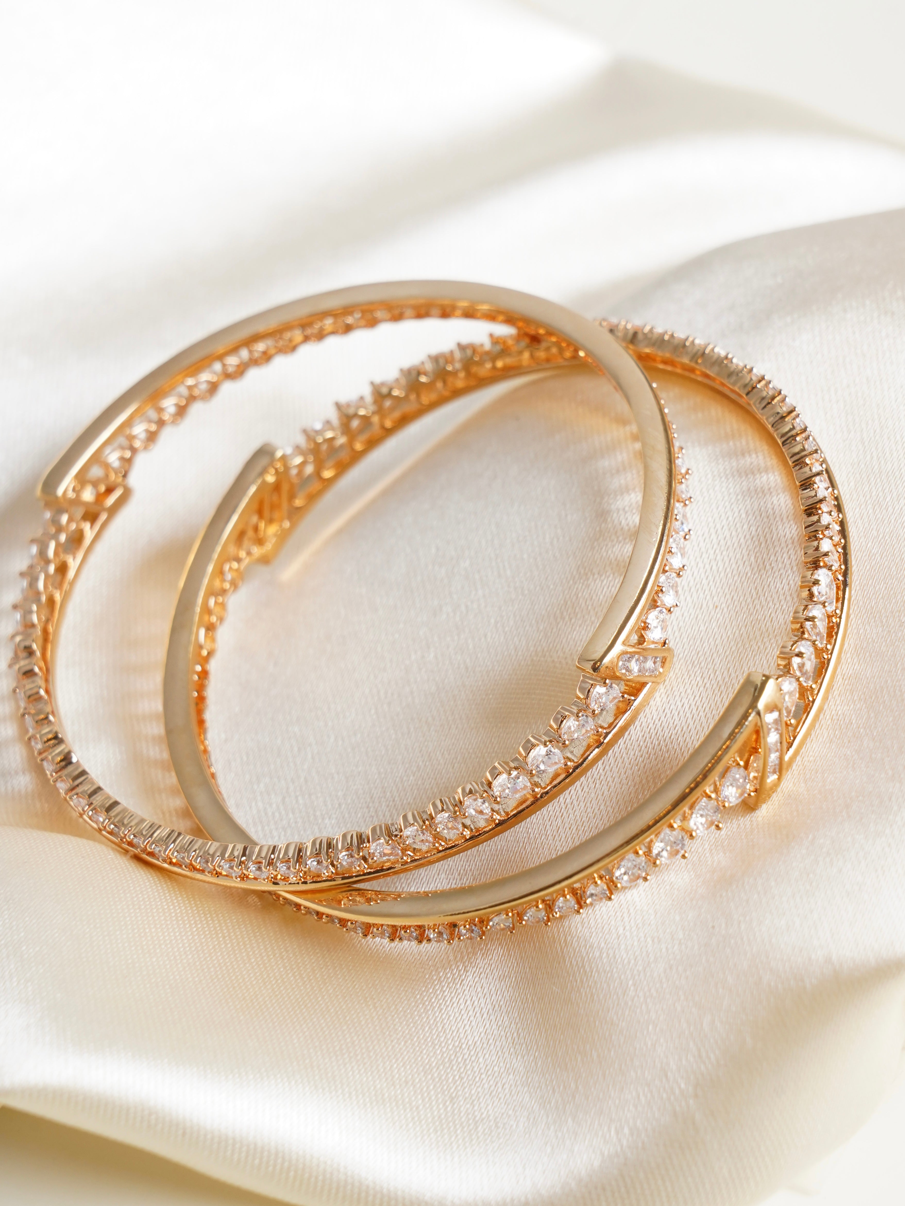 Close-up of elegant gold bangles with fine geometric cutwork in polished finish