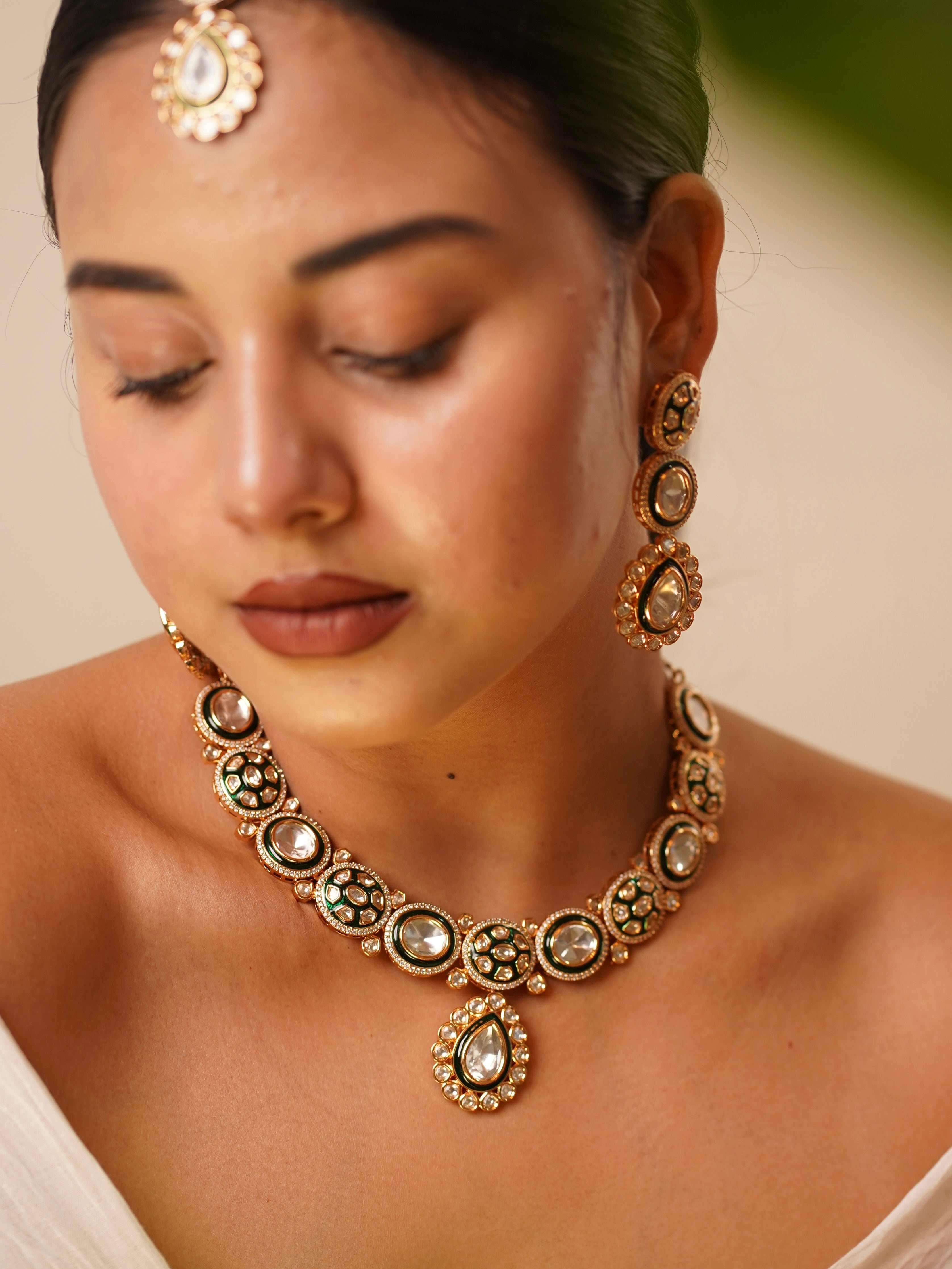 Polki necklace set with intricate gold design, includes earrings and maangtikka, regal appearance