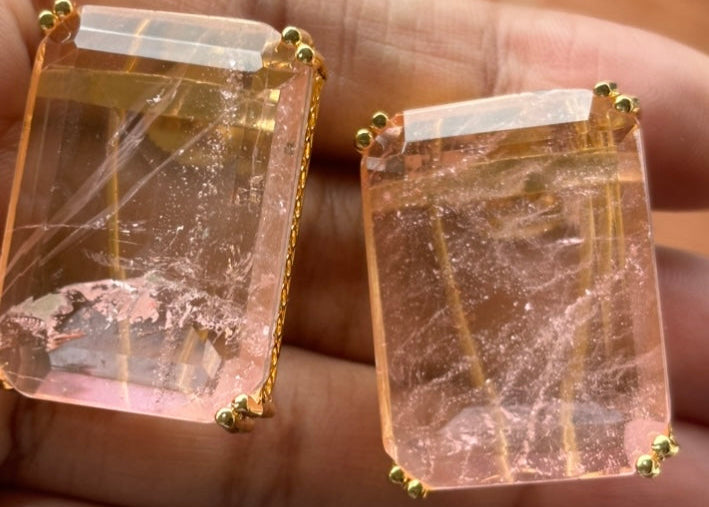 Front close-up of elegant rectangular gemstone earrings with gold borders