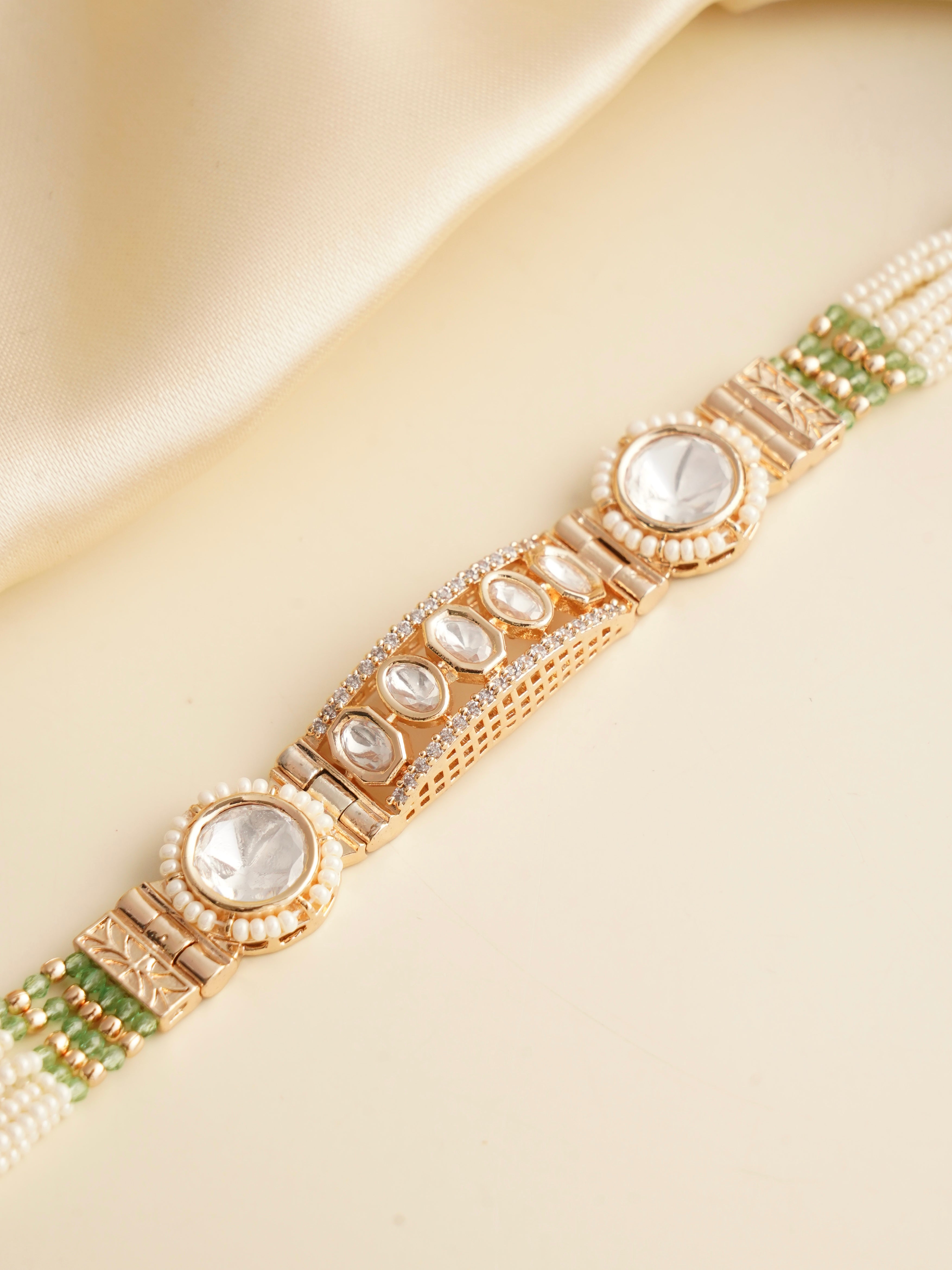Side view of rakhi bracelet showing kundan stone and pearl string