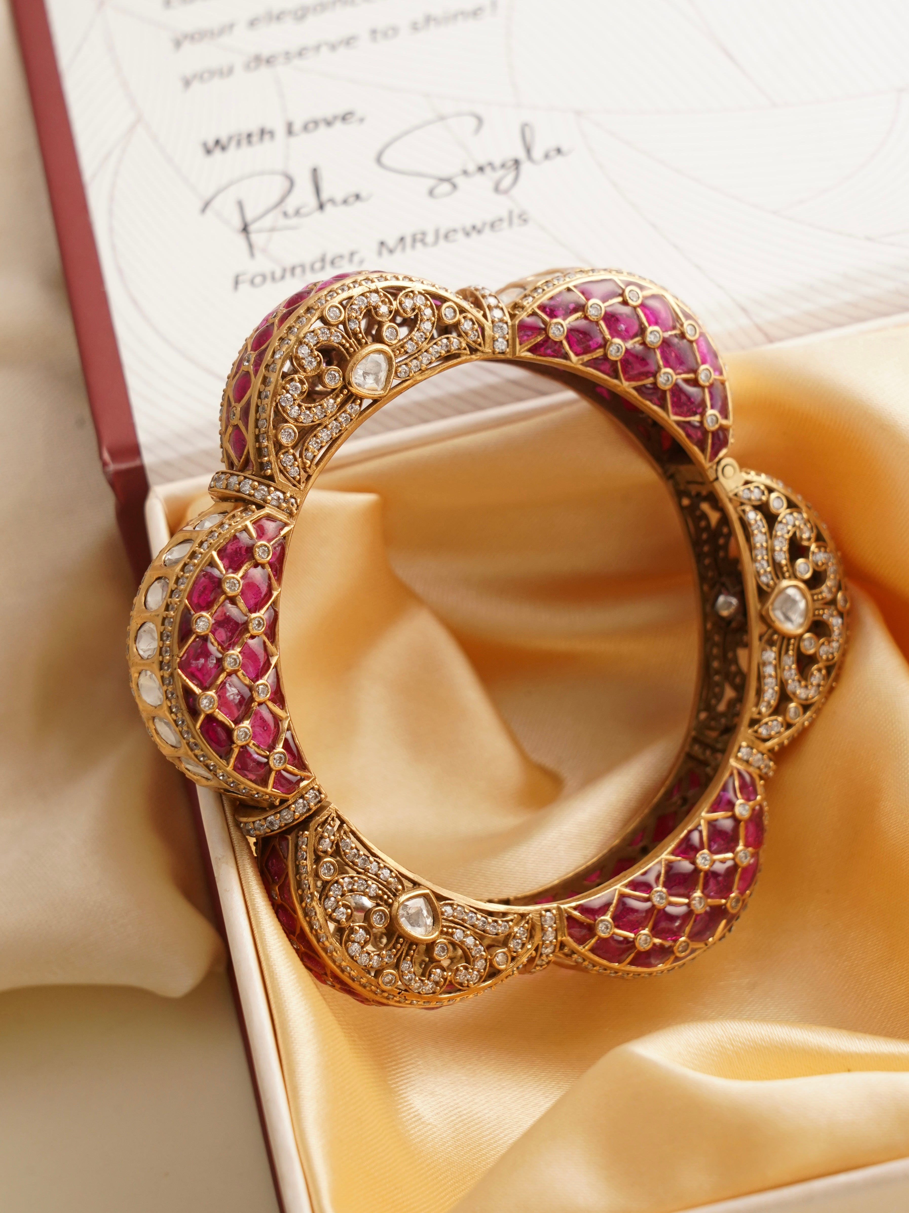 Top view of emerald-ruby kada showcasing polki stones and floral-inspired design