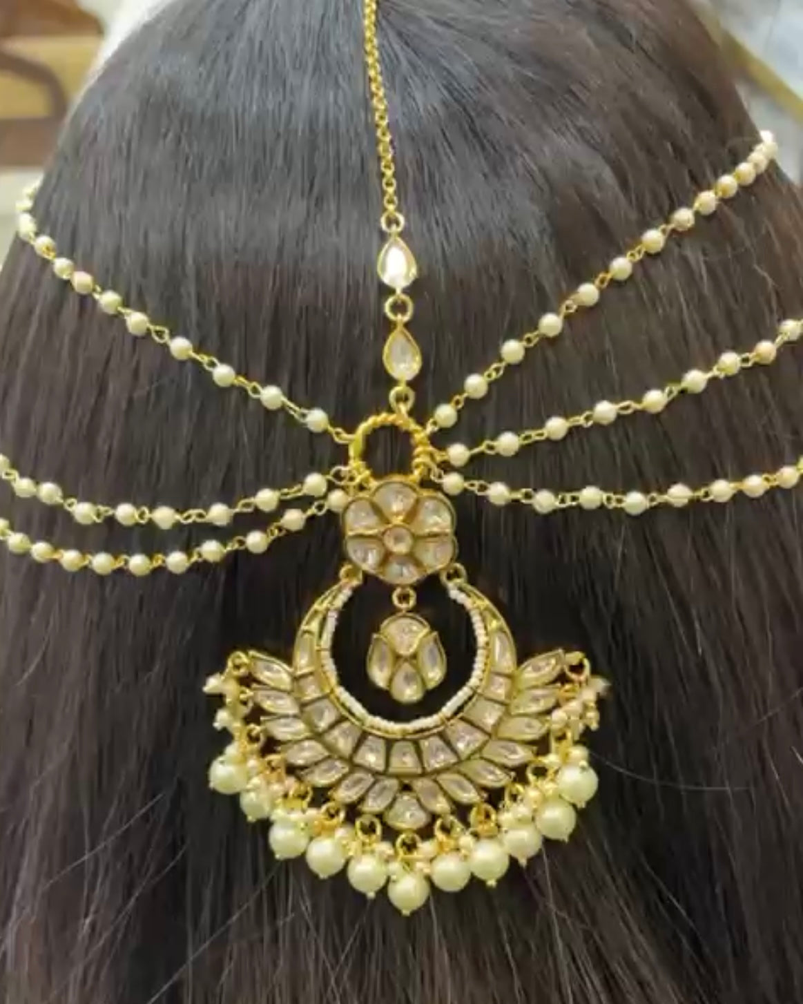 Angled view of brass matha patti with central pendant and kundan detailing