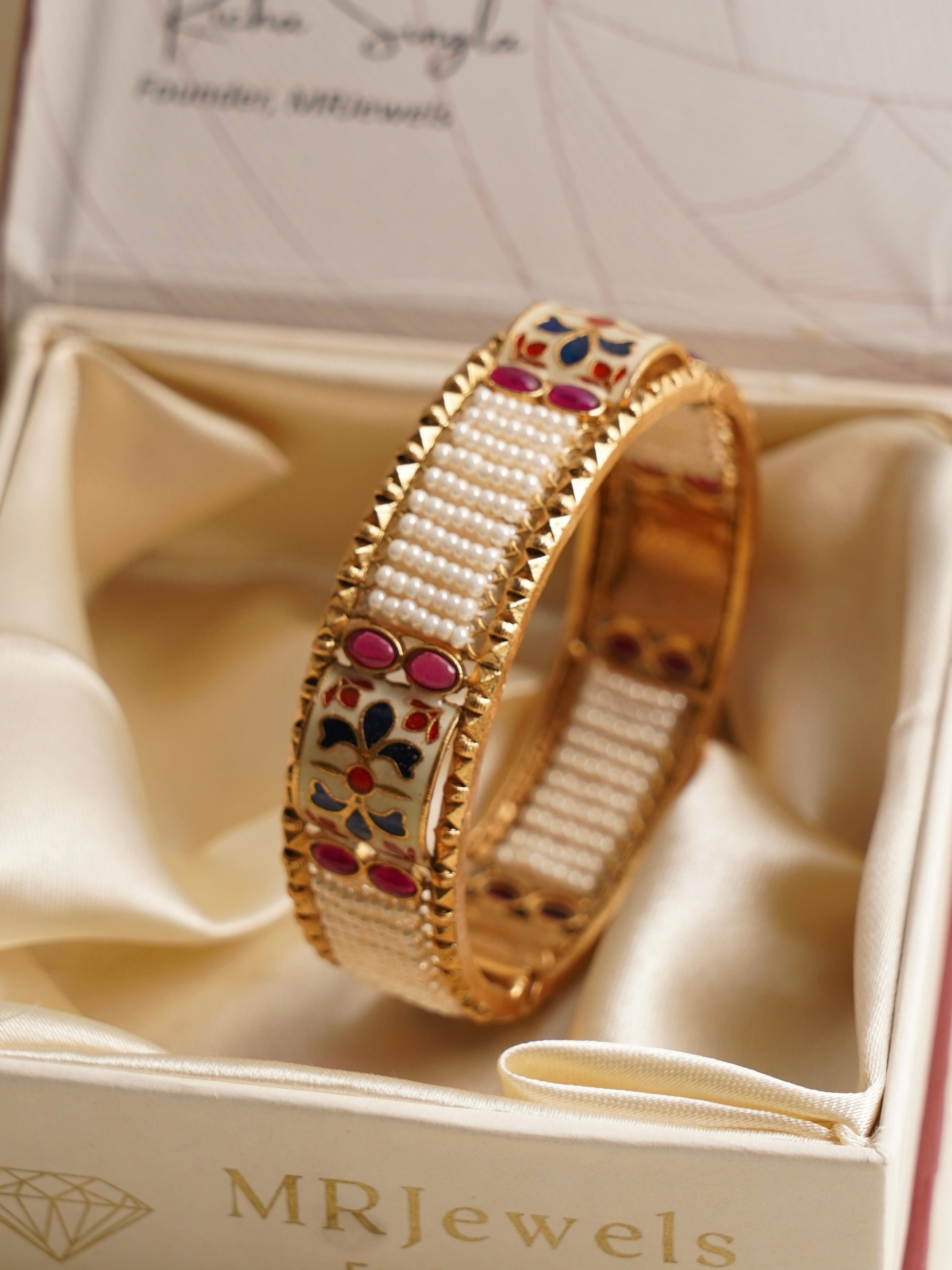 bridal bangles with pearl rows and floral enamelwork with ruby-studded accents