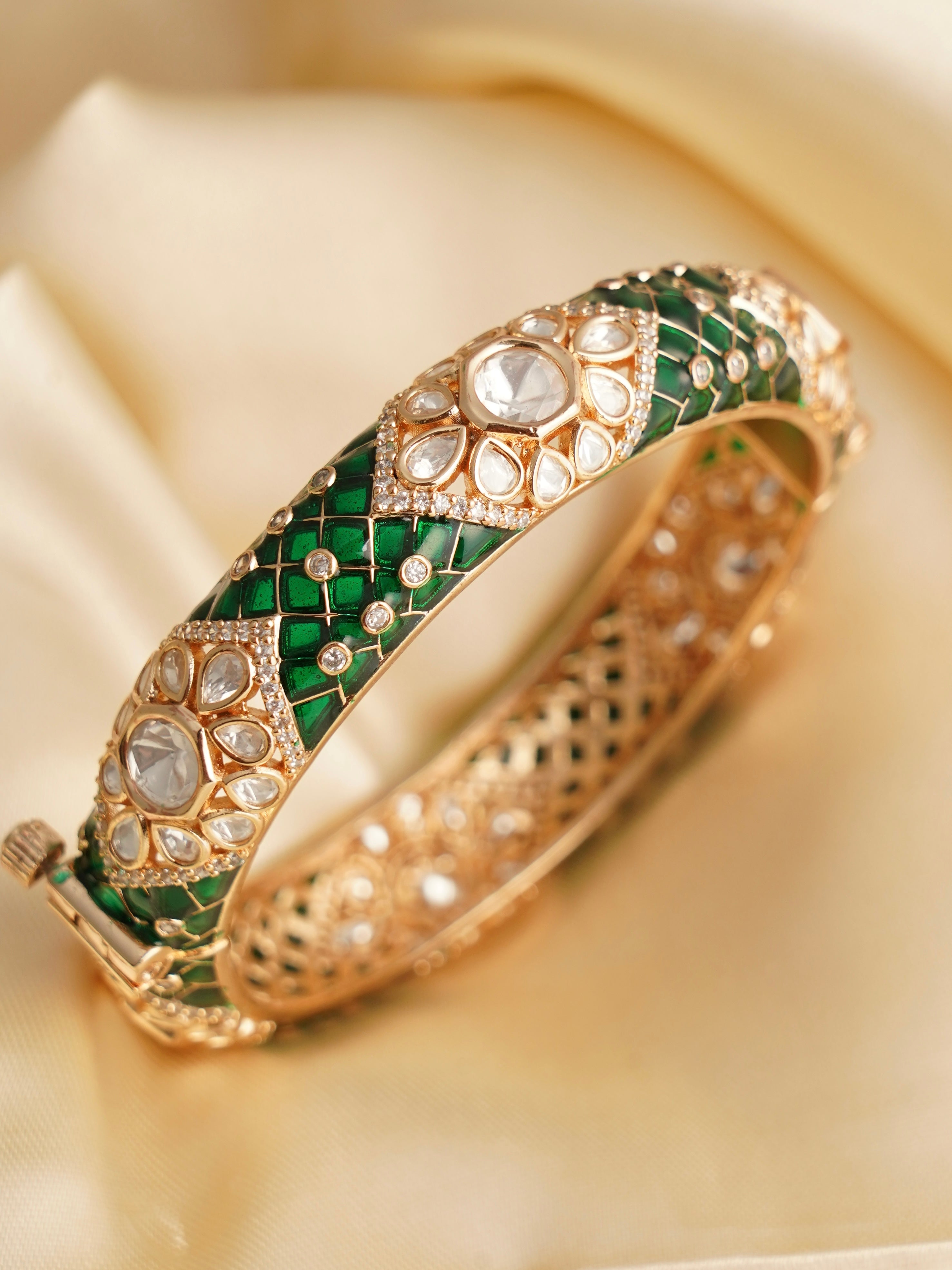 Close-up of heritage-inspired kundan bangle pair with enamel patterns and gemstone inlays