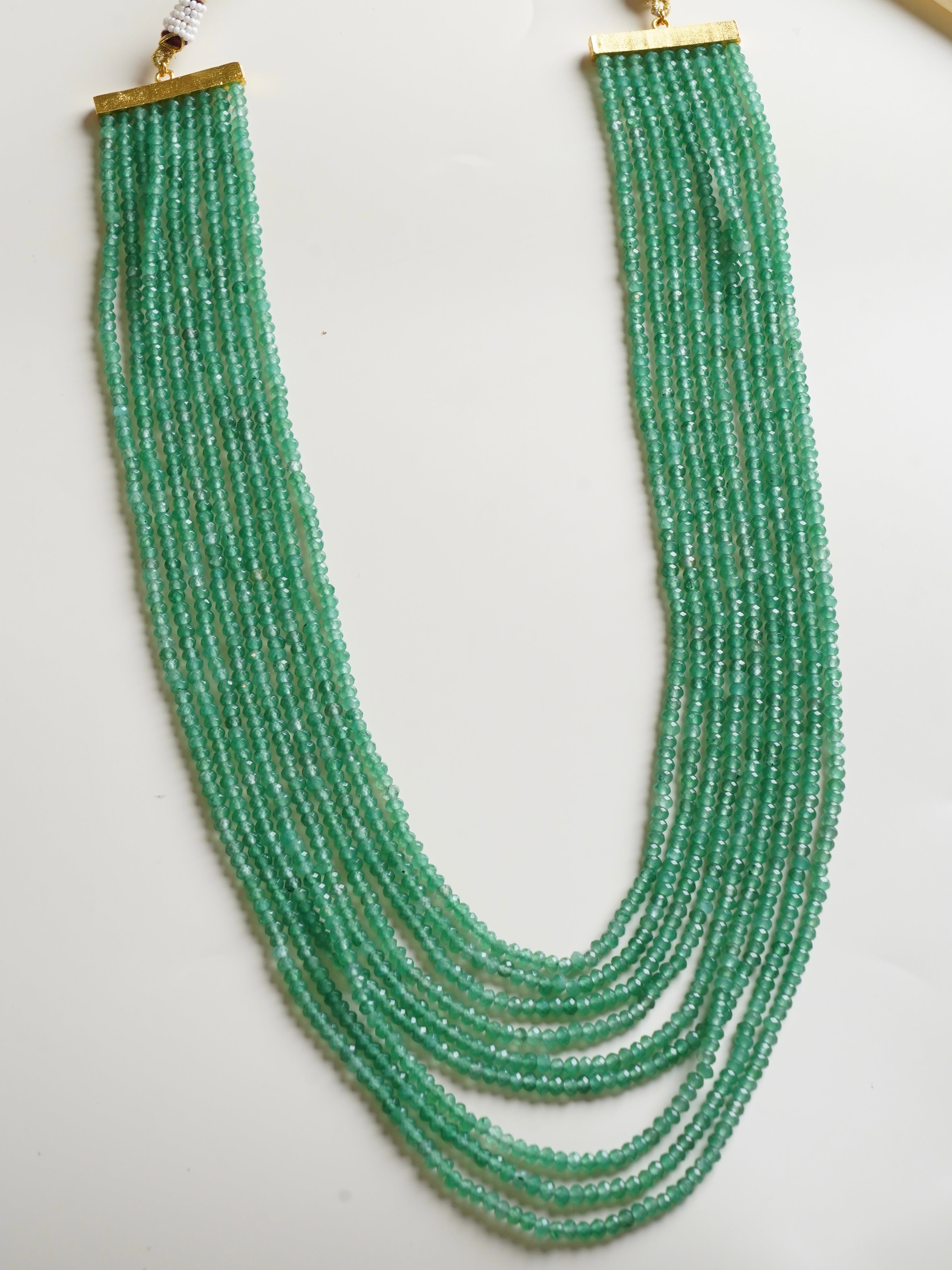 Detail of multi-strand gemstone necklace with polished pink and blue bead layers