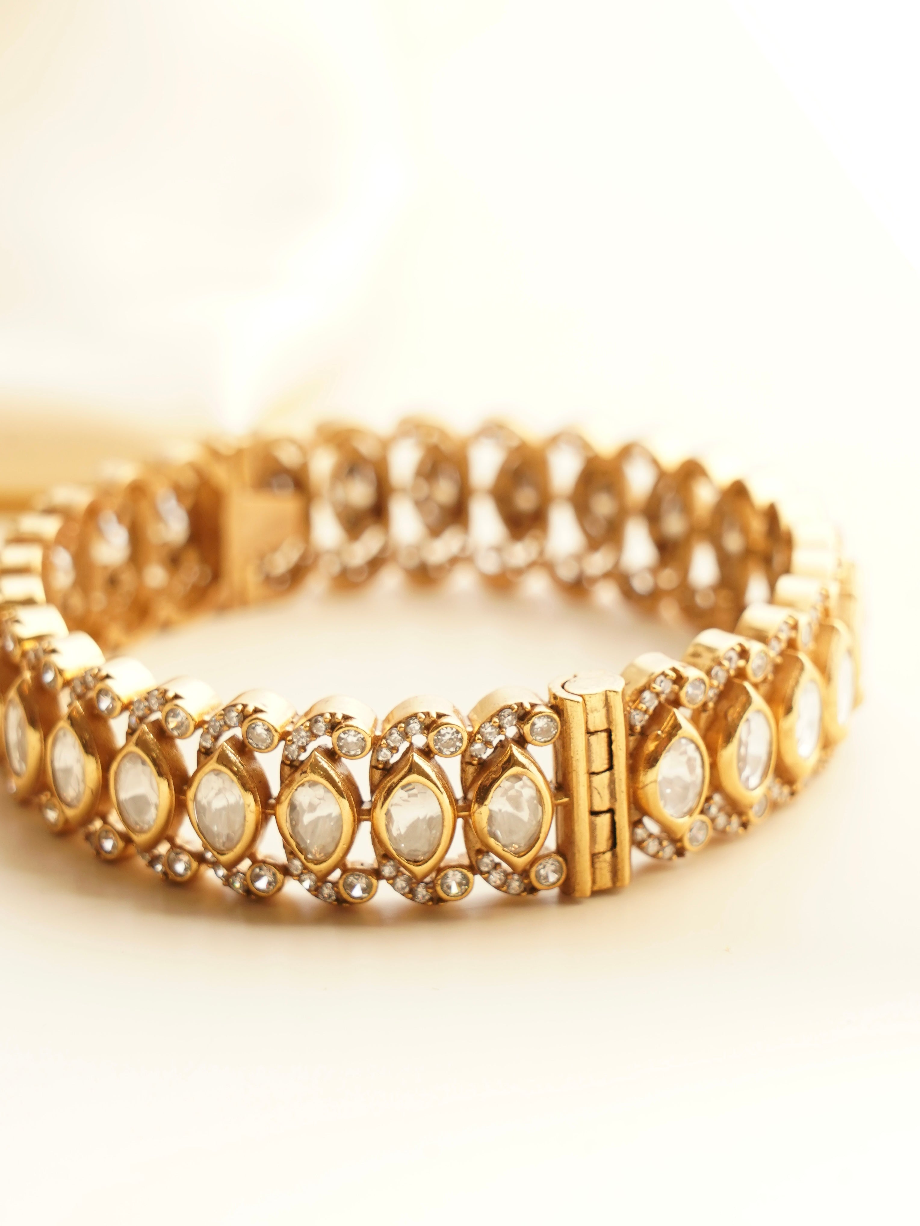 Side view of kundan bangle with detailed stone setting and radiant gold finish