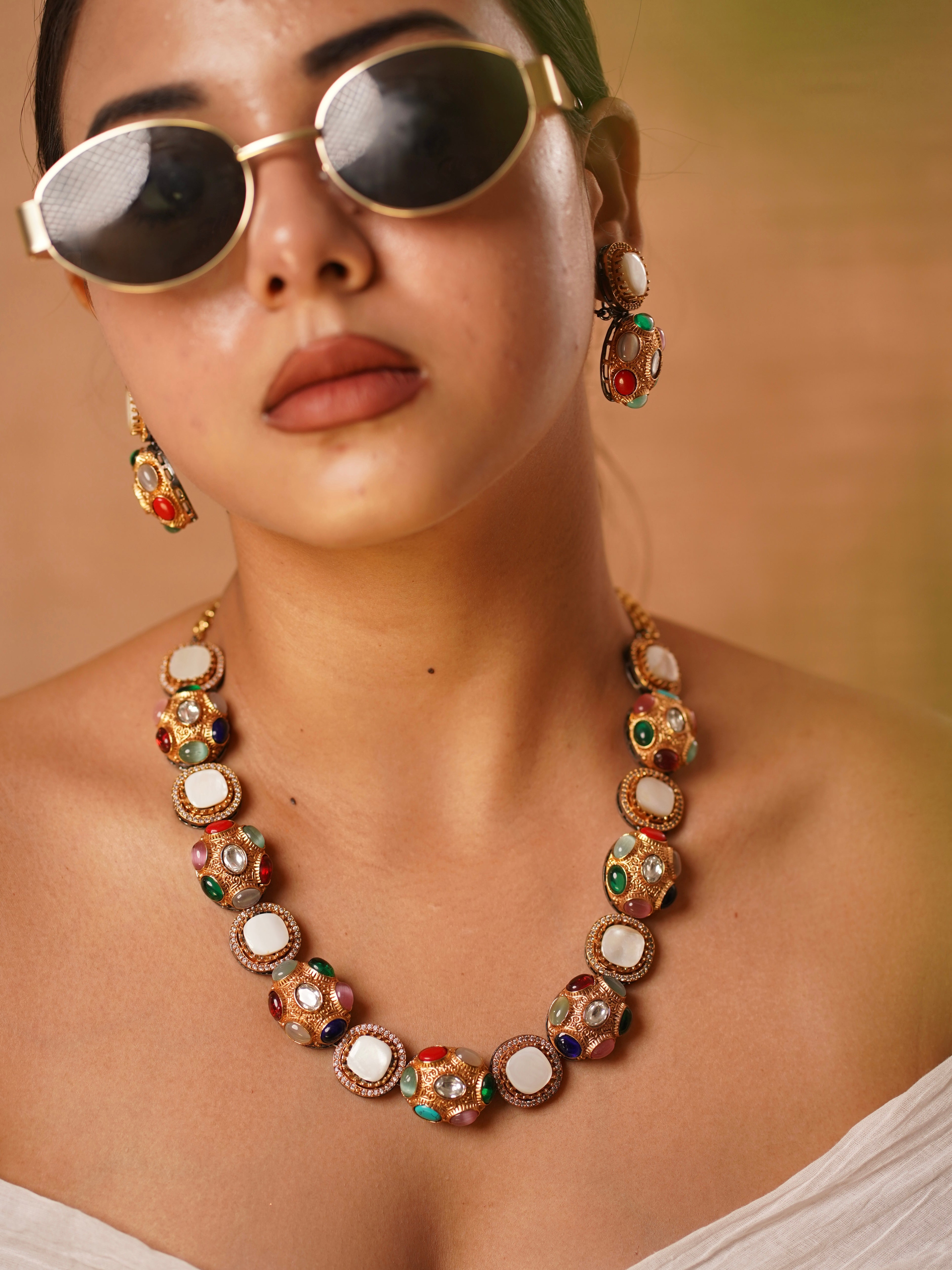 Multigem statement necklace with globe-shaped beads and colorful gemstones in antique gold finish