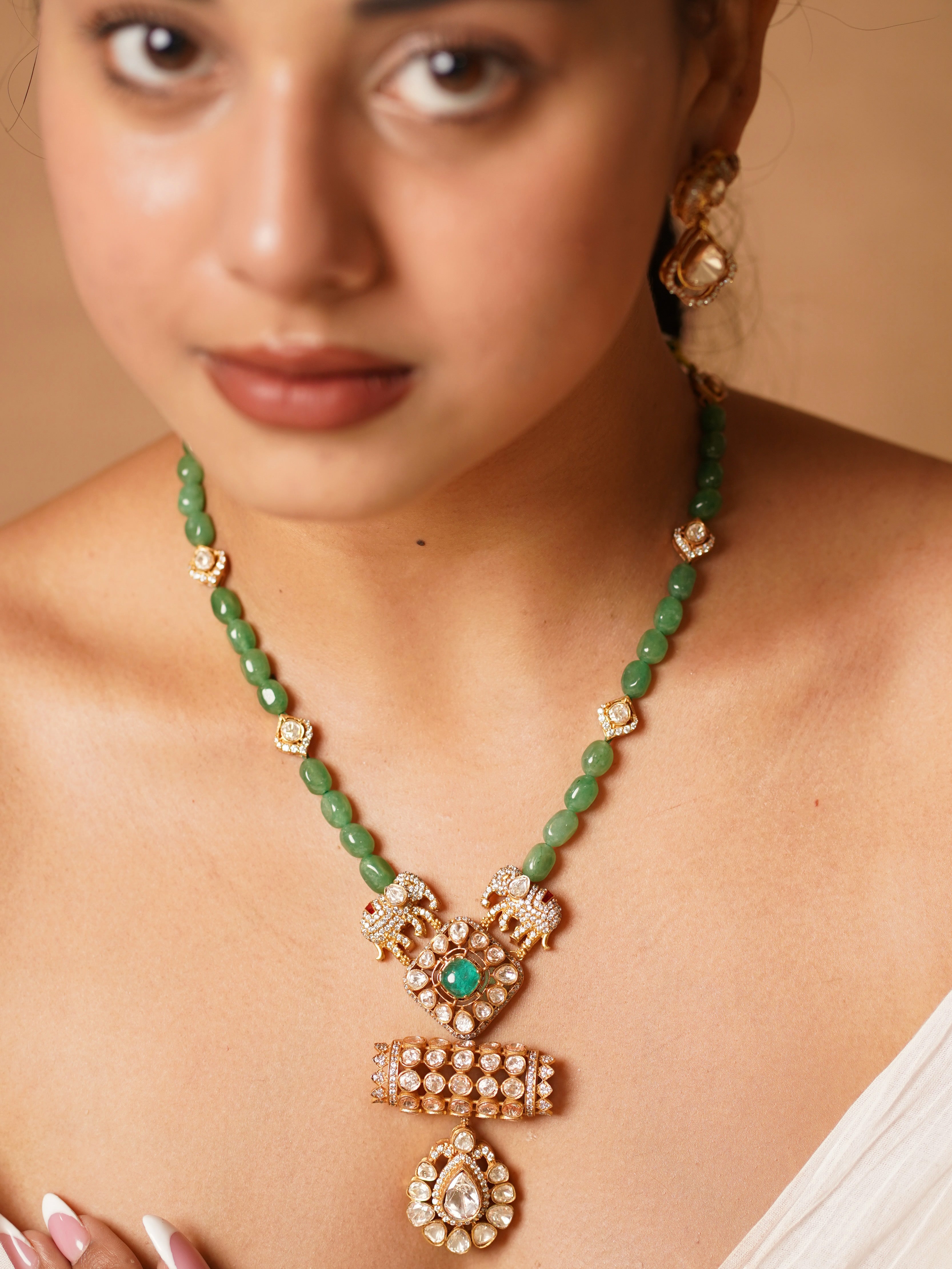 Side view of kundan necklace featuring elephant motif and emerald centre