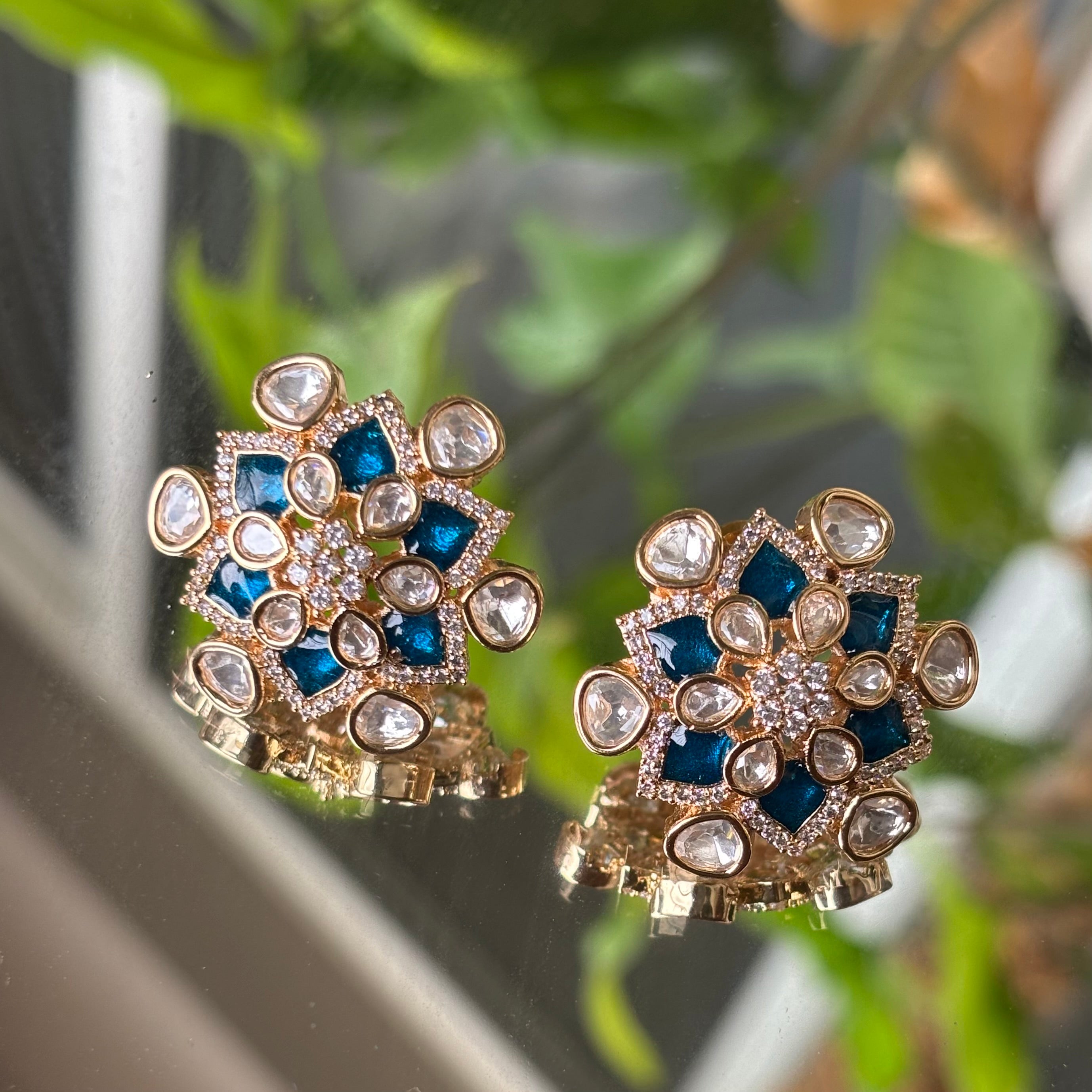 Floral kundan studs with enamel petals and mirror-polki accents in top view