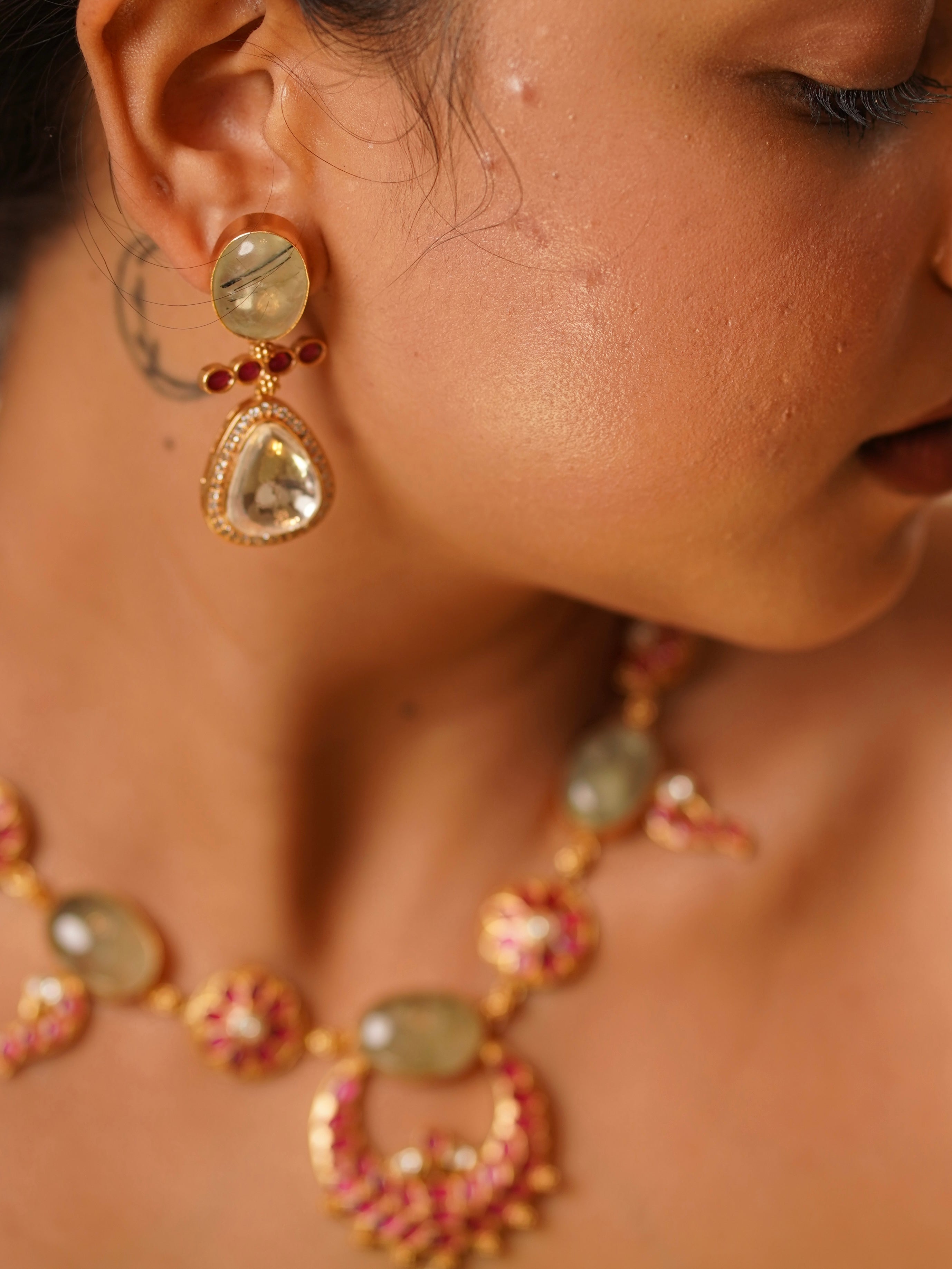 angled view of kempu necklace set with prehnite and kundan stones in rich brass finish