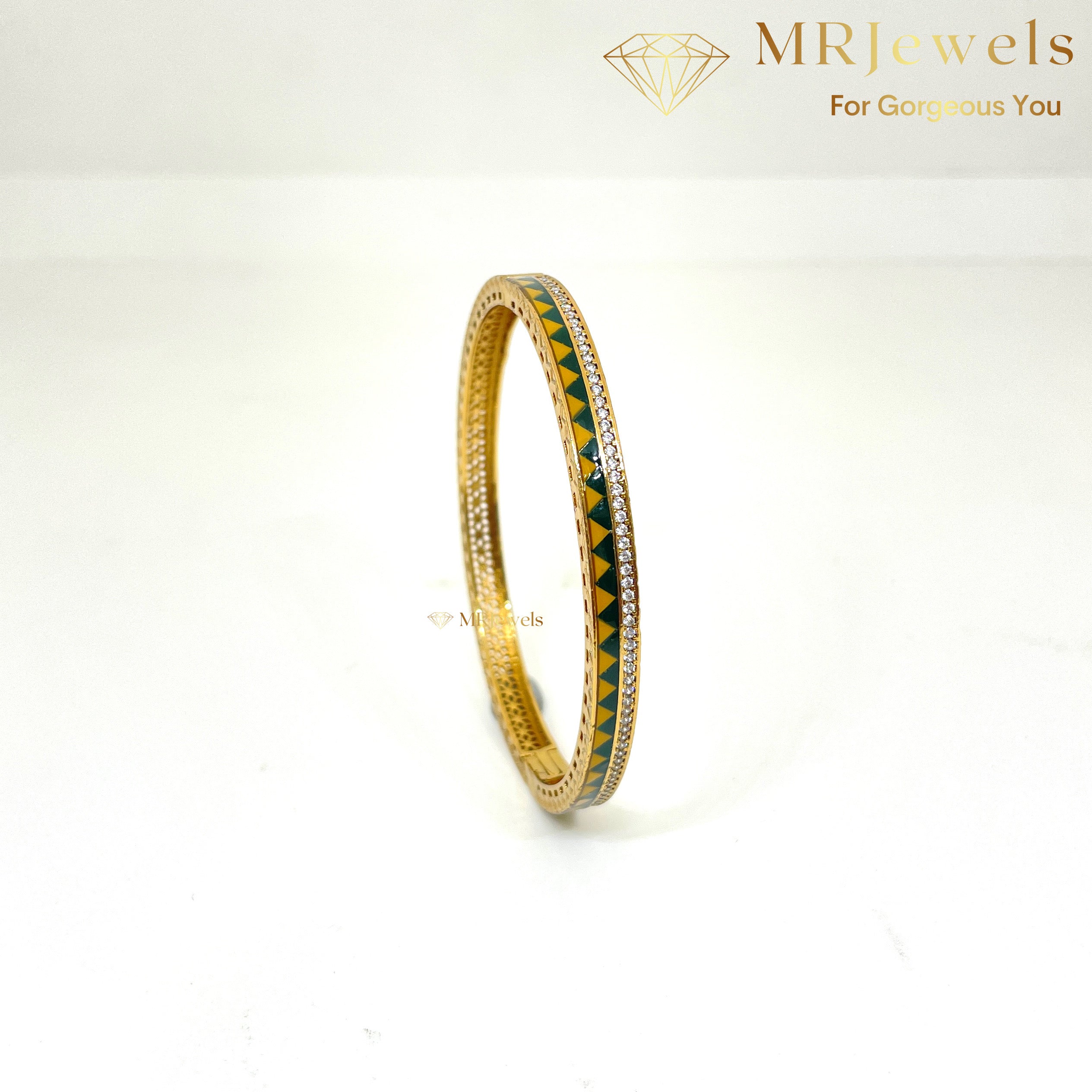 Macro shot highlighting enamel panel and embedded CZ stones on gold-tone bracelet