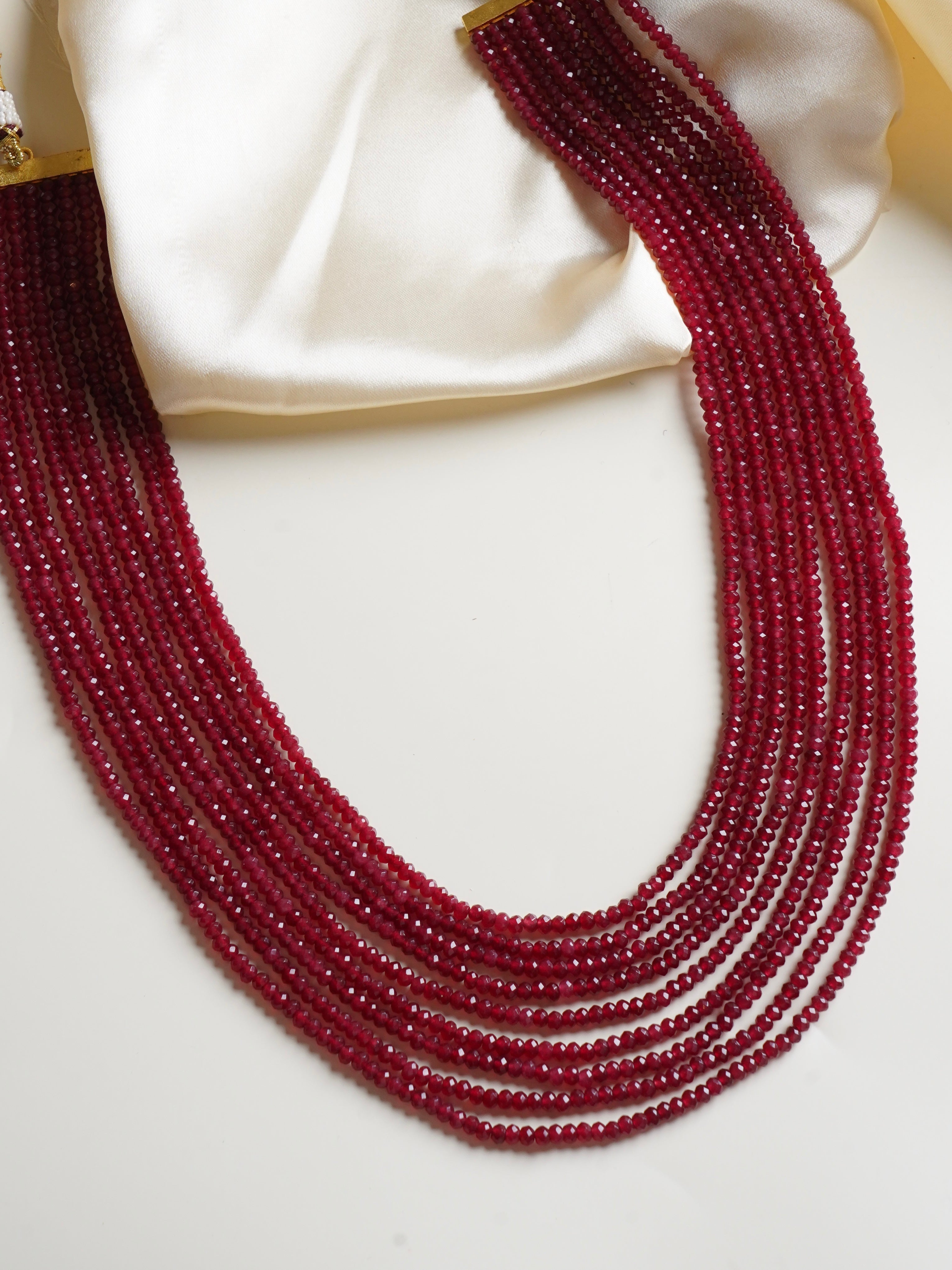 Side view of layered beaded necklace featuring faceted multicolor gemstone strands